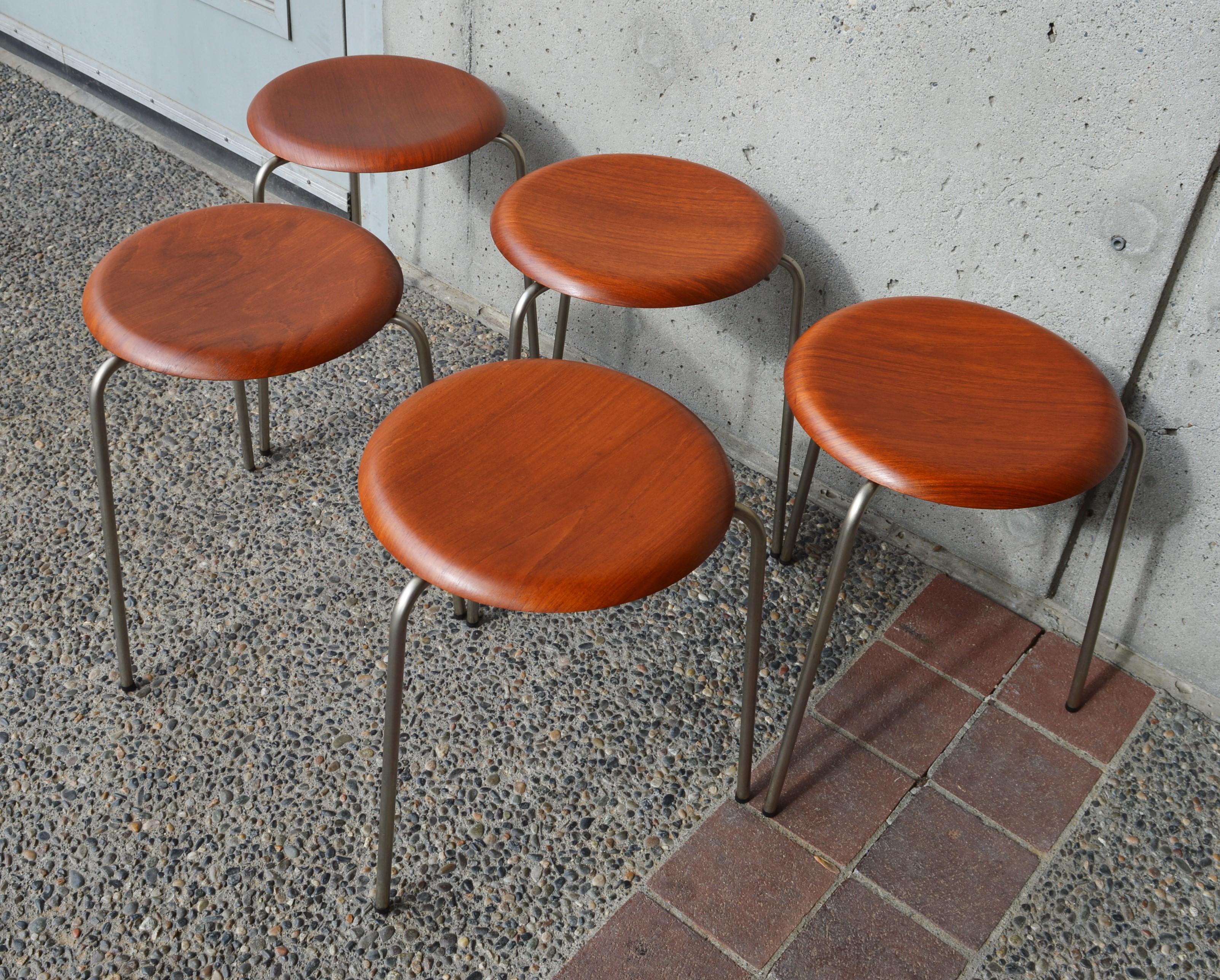 Gorgeous and rare set of 5 dot stools by Arne Jacobsen for Fritz Hansen, 1960s. This stackable collection features a curved, bent ply teak top and the original three legged metal base. Restored and in gorgeous condition (one seat has 2 vague