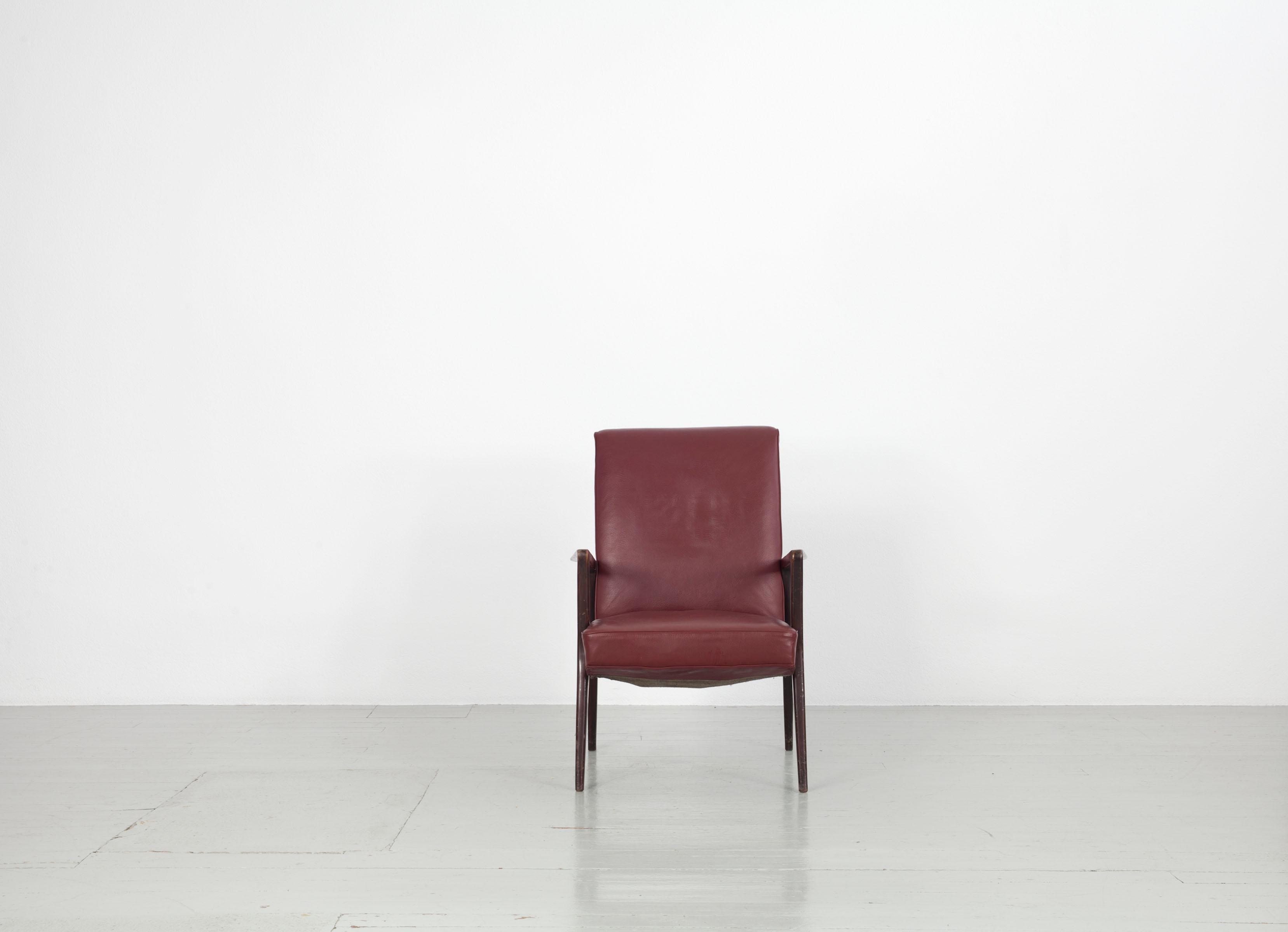 Dieser Satz von fünf Sesseln wurde in den 1950er Jahren in Italien hergestellt. Der Möbelkorpus aus dunkelrotem, originalem Lederimitat ruht auf einem dunkel gebeizten Holzrahmen. Der Sessel weist deutlich sichtbare Gebrauchsspuren auf.

Zögern Sie