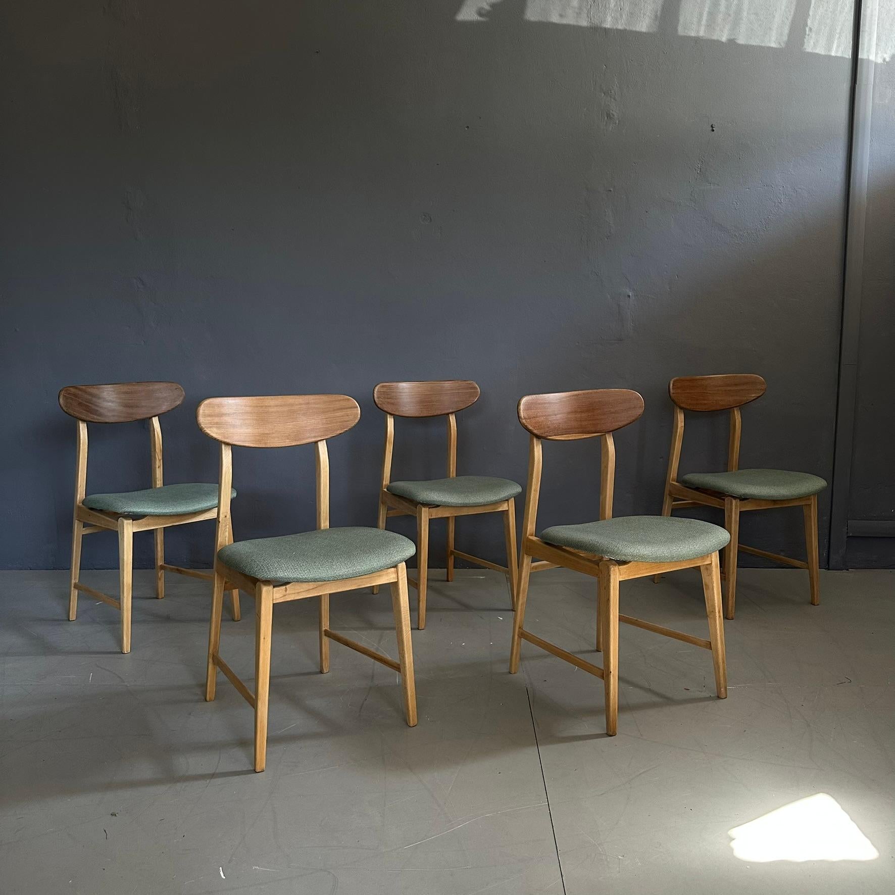 Set of five chairs from the 1960s.
The chairs have a light wood frame, with padded seats covered in a light green fabric and curved wooden backrests with visible grain.
The lines and style of the chairs are reminiscent of Nordic design.