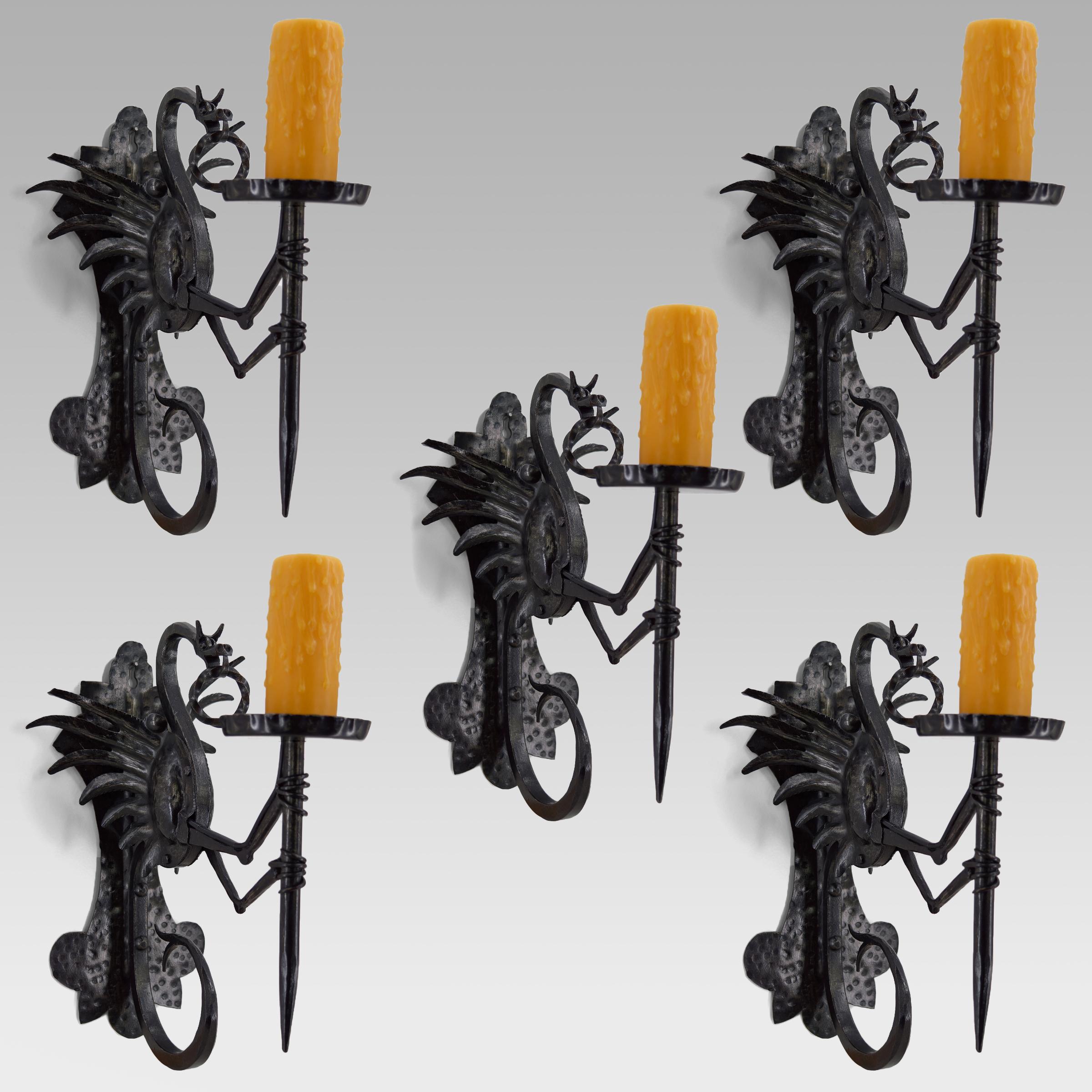 Wunderschönes Set von 5 schmiedeeisernen Wandleuchtern, die einen geflügelten Drachen darstellen, der eine Fackel / eine Fackel hält.

Gute Qualität der Herstellung: gut gemachte Gegenstände, schöne Patina des Metalls.

Neogotik/Jugendstil,