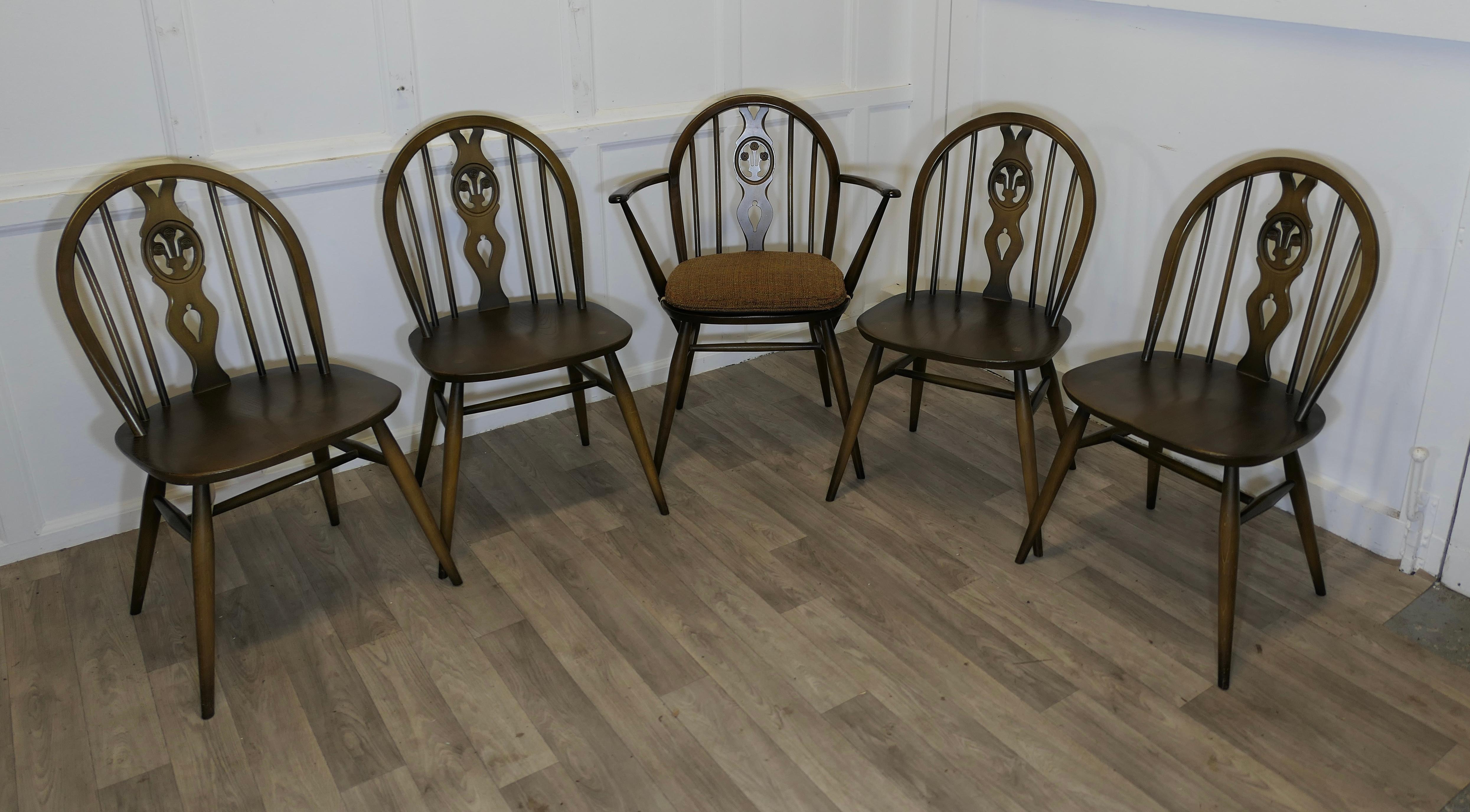Set of 5 Ercol Windsor Dining Chairs

The chairs are a classic design in the classic Windsor style with a wheel back, there are 4 single chairs and a carver chair complete with its own original cushion
All the joints are all good, there is no