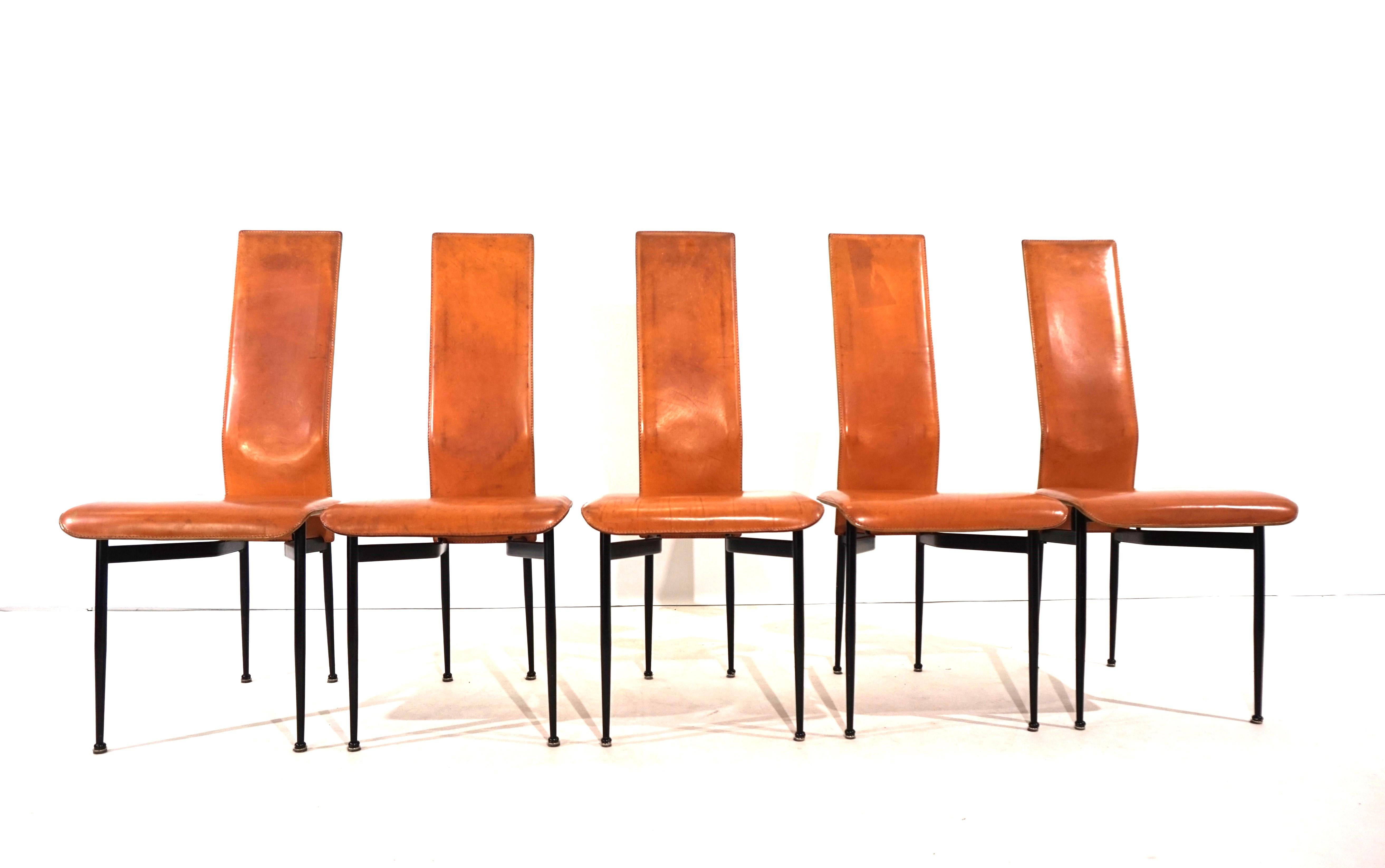 This group of 5 Fasem S44 dining chairs comes in a whisky-colored leather with a distinctive patina on all chairs, which is what makes these chairs so charming, especially in this color. The leather and the black painted metal frame otherwise only
