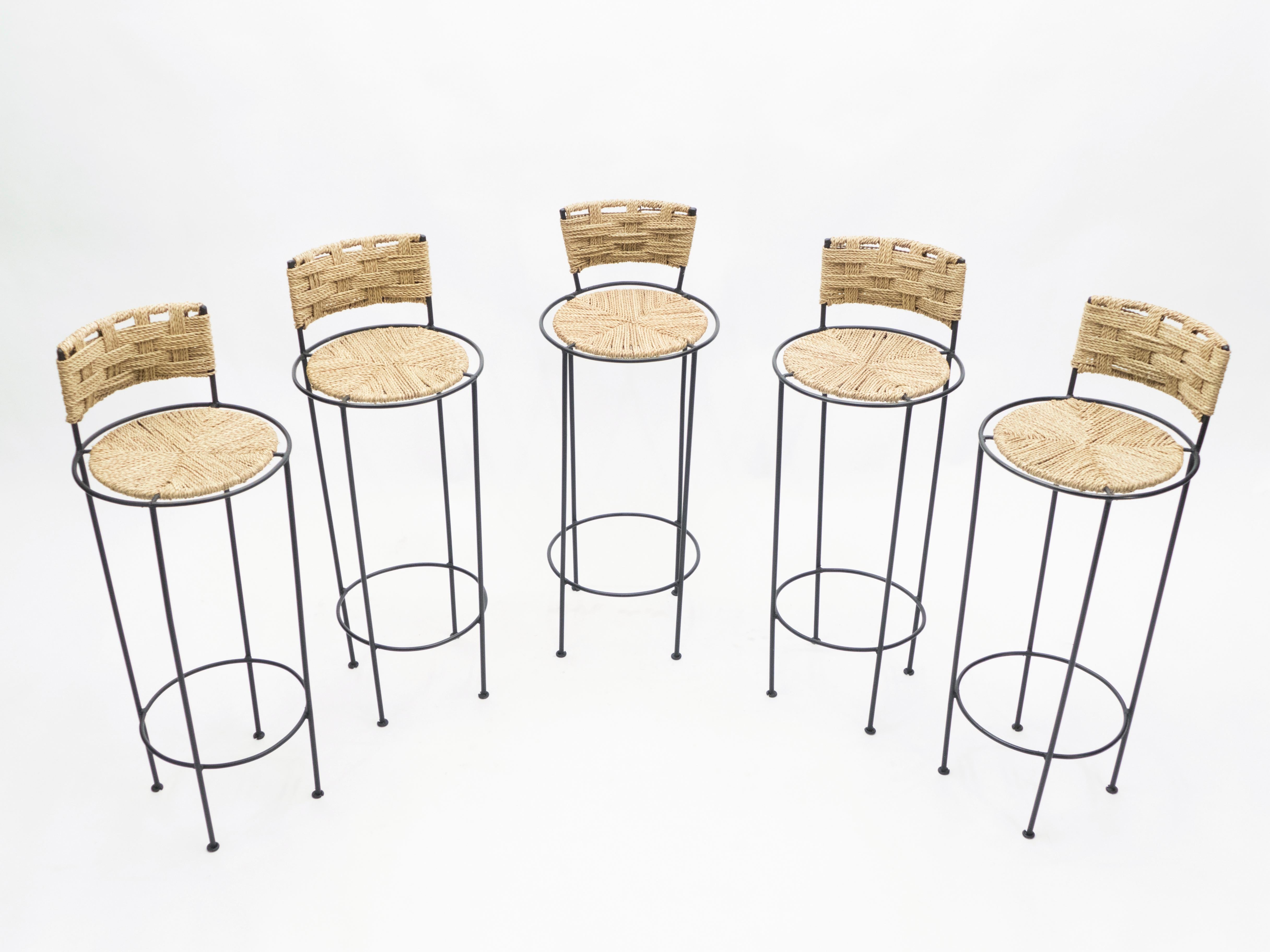 Beautiful patina is evident along the abaca rope seating and backrest of this set of five bar stools by Adrien Audoux et Frida Minet, giving away their vintage status. This natural style is typical of the French design of Audoux-Minet. Timeless