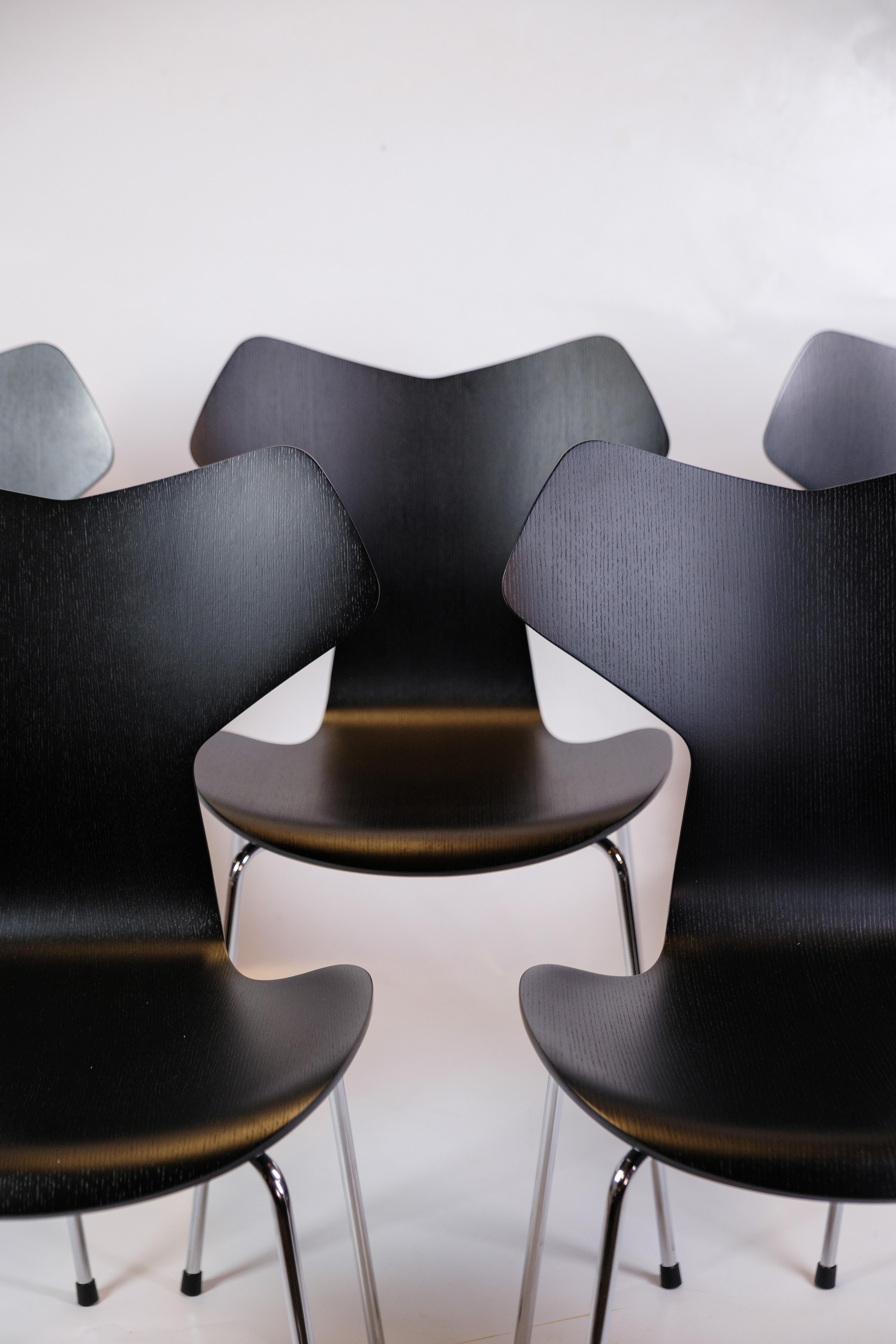Questo set di cinque sedie Grand Prix, modello 3130, disegnate da Arne Jacobsen e prodotte da Fritz Hansen, rappresenta un pezzo iconico del design danese. Le sedie sono laccate di nero, il che conferisce loro un aspetto moderno ed elegante.

La