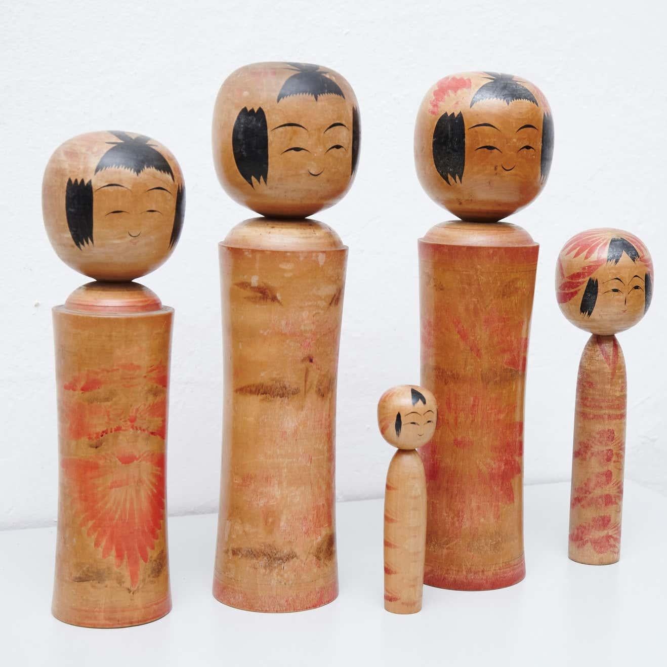 Add a touch of traditional Japanese charm to your home decor with this exquisite set of 5 Kokeshi dolls. Handmade by skilled artisans from wood, each doll features a simple trunk as a body and an enlarged head with lines defining the face. One