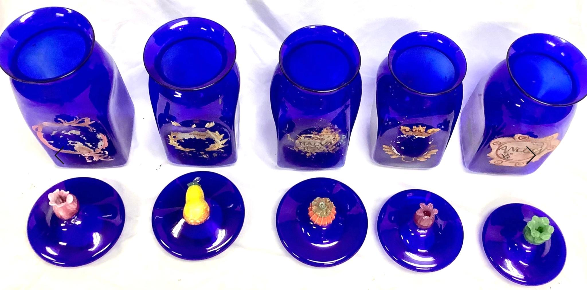 Rare vintage cobalt blue venetian glass apothecary jars. Set of 5. Each jar has a lid with glass fruit or flower as handle. Perfect for vanity or bathroom storage. Very good condition, some wear to painted labels and two glass lid repairs (see