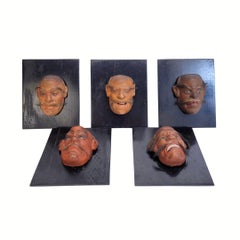 Set of 5 Meiji Japanese Noh theater masks, mounted on ebonized wood.