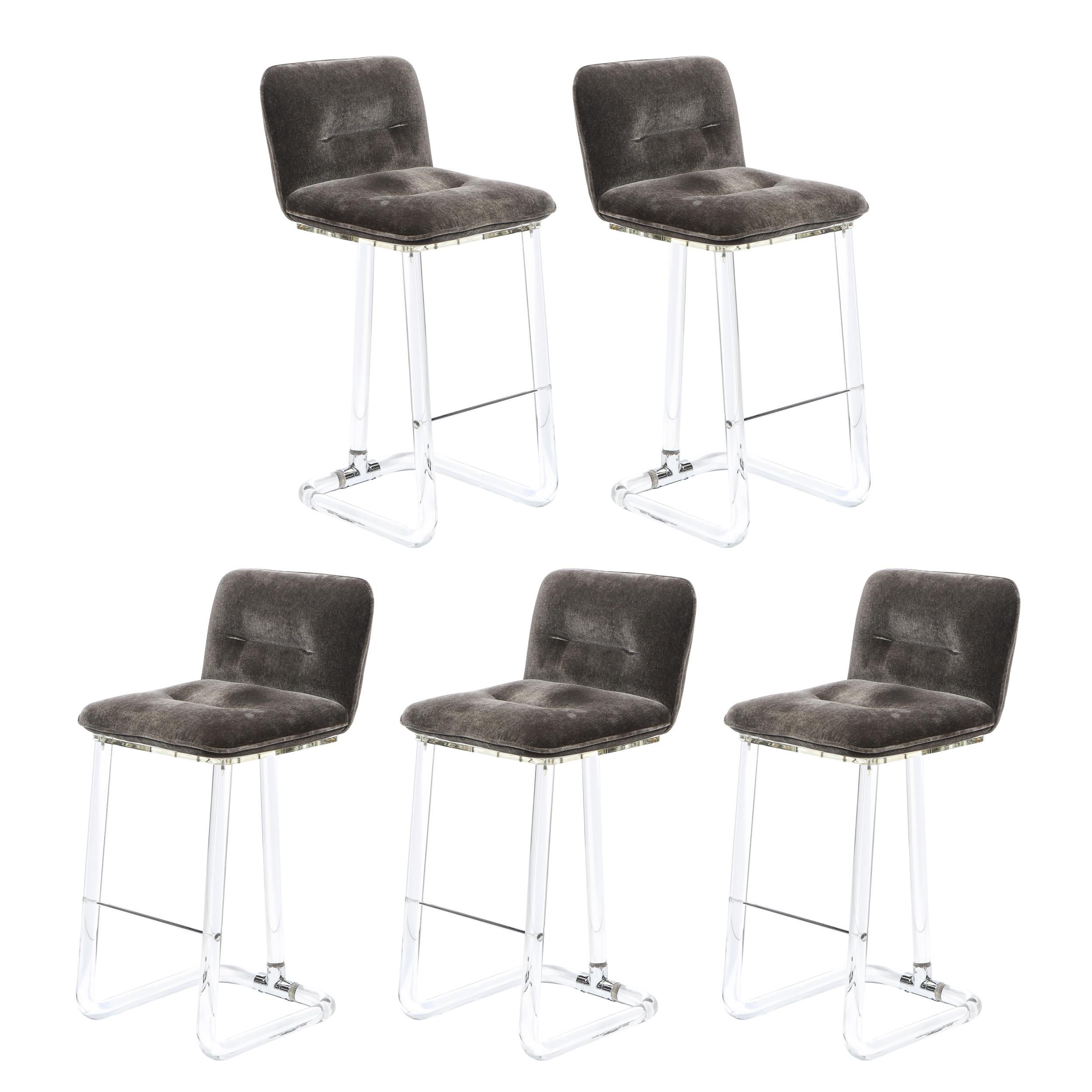 This stunning set of five Mid-Century Modern swiveling bar stools were realized by Leon Frost of Lion in Frost in the United States circa 1975. They feature a tufted seat and back with button detailing in slate mohair sitting atop two cylindrical