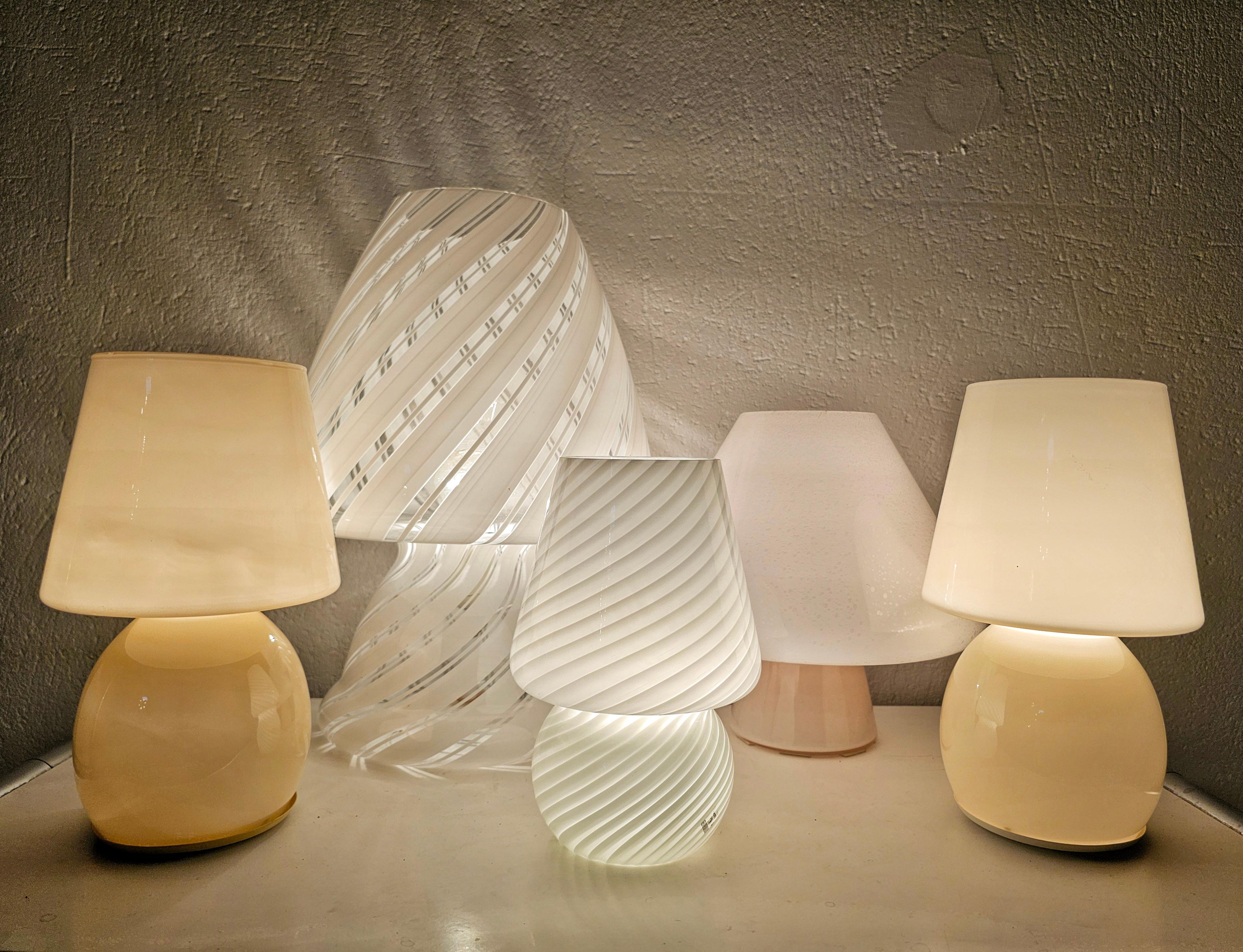 Ensemble de 5 lampes en forme de champignon en verre de Murano. Ils existent en différentes tailles et couleurs, dont deux seulement sont identiques, celles de couleur crème. La plus grande lampe a été conçue par Gino Vistosi, tandis que la plus