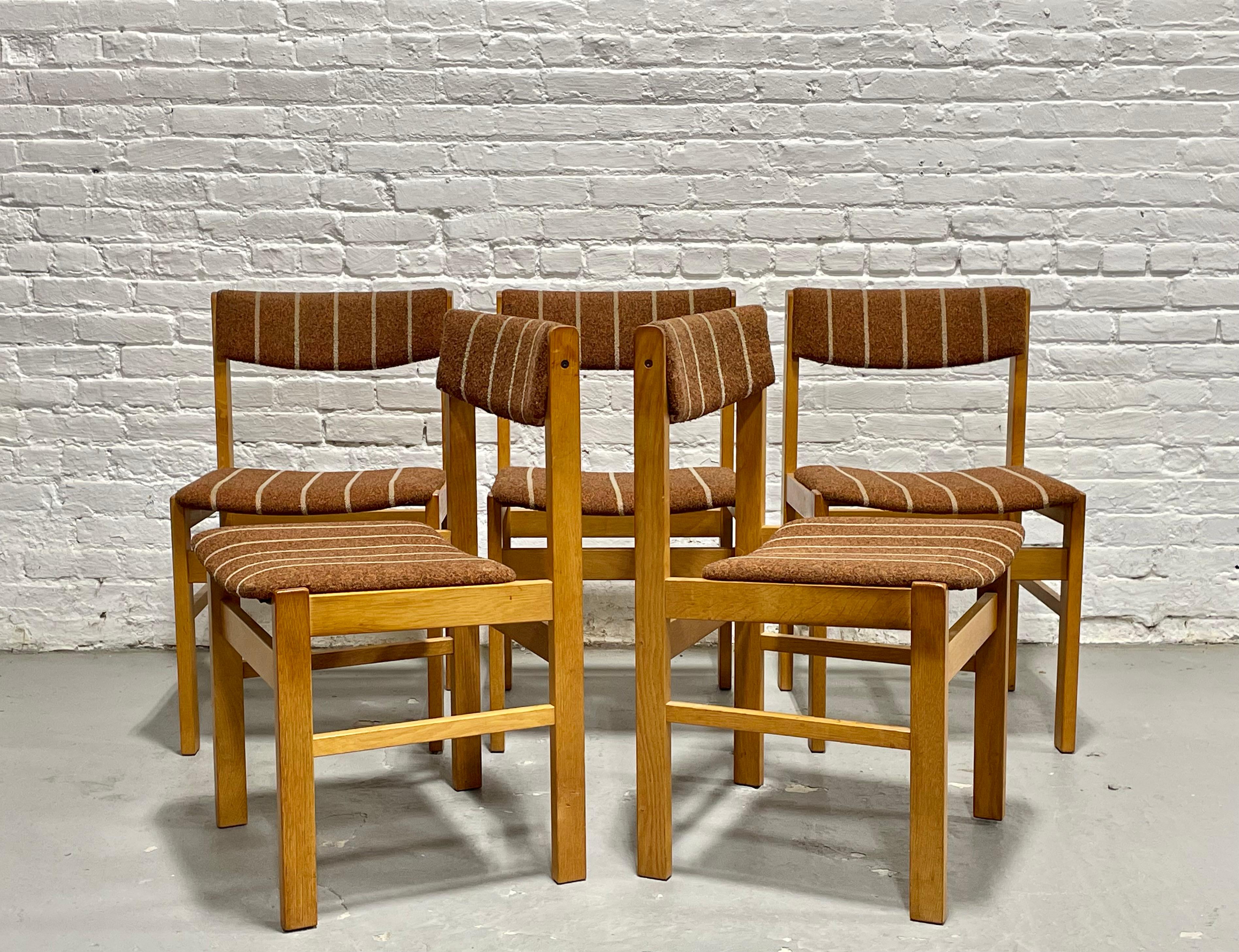 Set di cinque sedie da pranzo moderne del Mid Century con struttura in rovere massiccio e tappezzeria originale in lana testurizzata in una calda tonalità marrone chiaro con dettagli gessati color crema. Il profilo pulito, gli schienali dolcemente