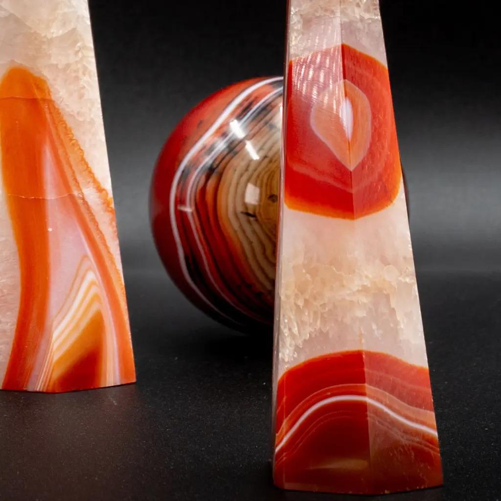 Elevate your interior spaces with this set of five Sardonyx Agate obelisks — a natural stone distinguished by its warm, intense hues ranging from deep red to luminous orange, subtly veined with white. Each obelisk is finely polished to reveal the