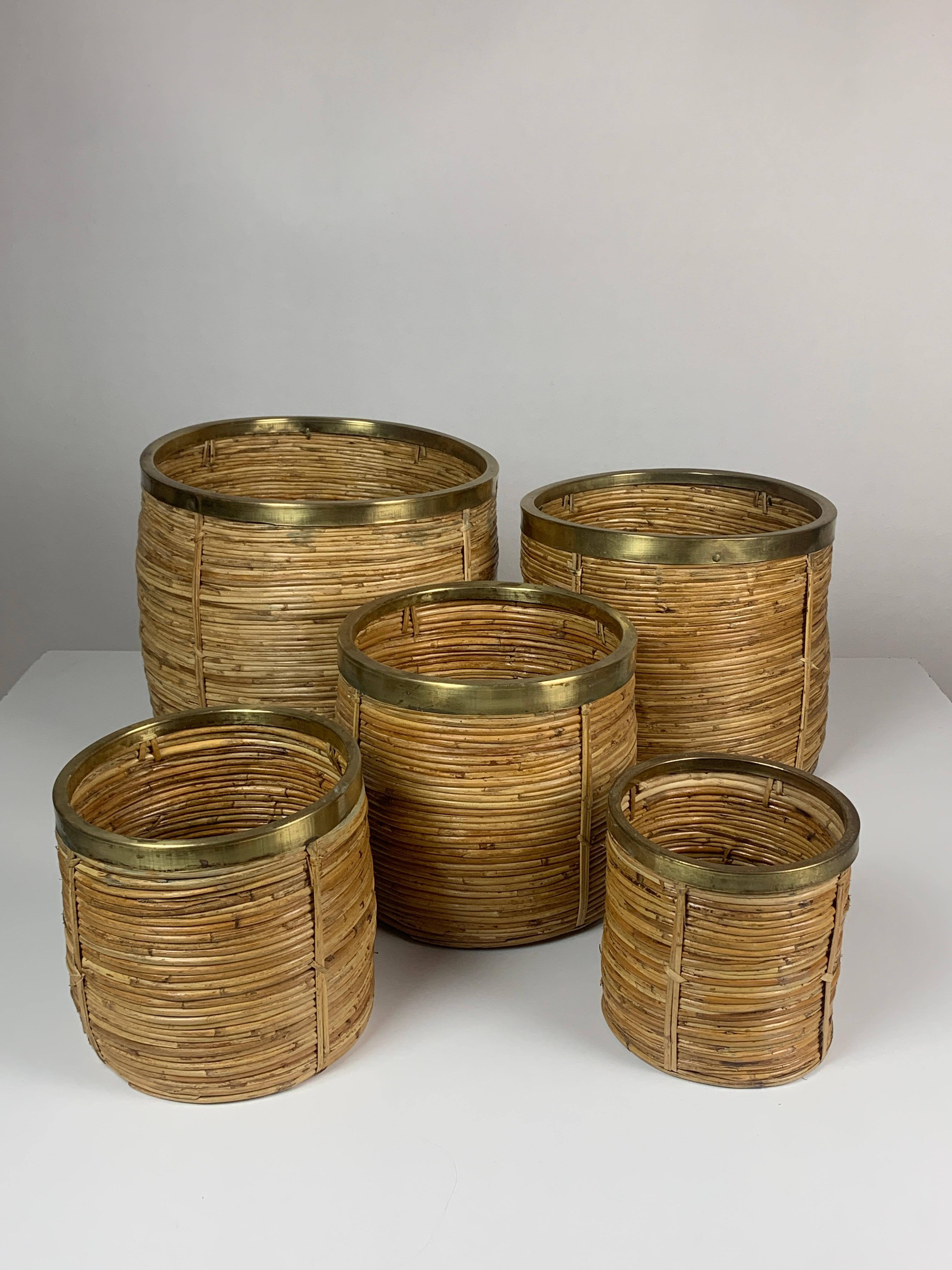 Wonderful and complete set of 5 rattan pencil reed and brass plant holders or baskets. As can be seen in the pics all the baskets easily fit in each other for easy storage. The set is in great vintage condition The brass has a lovely patina and has