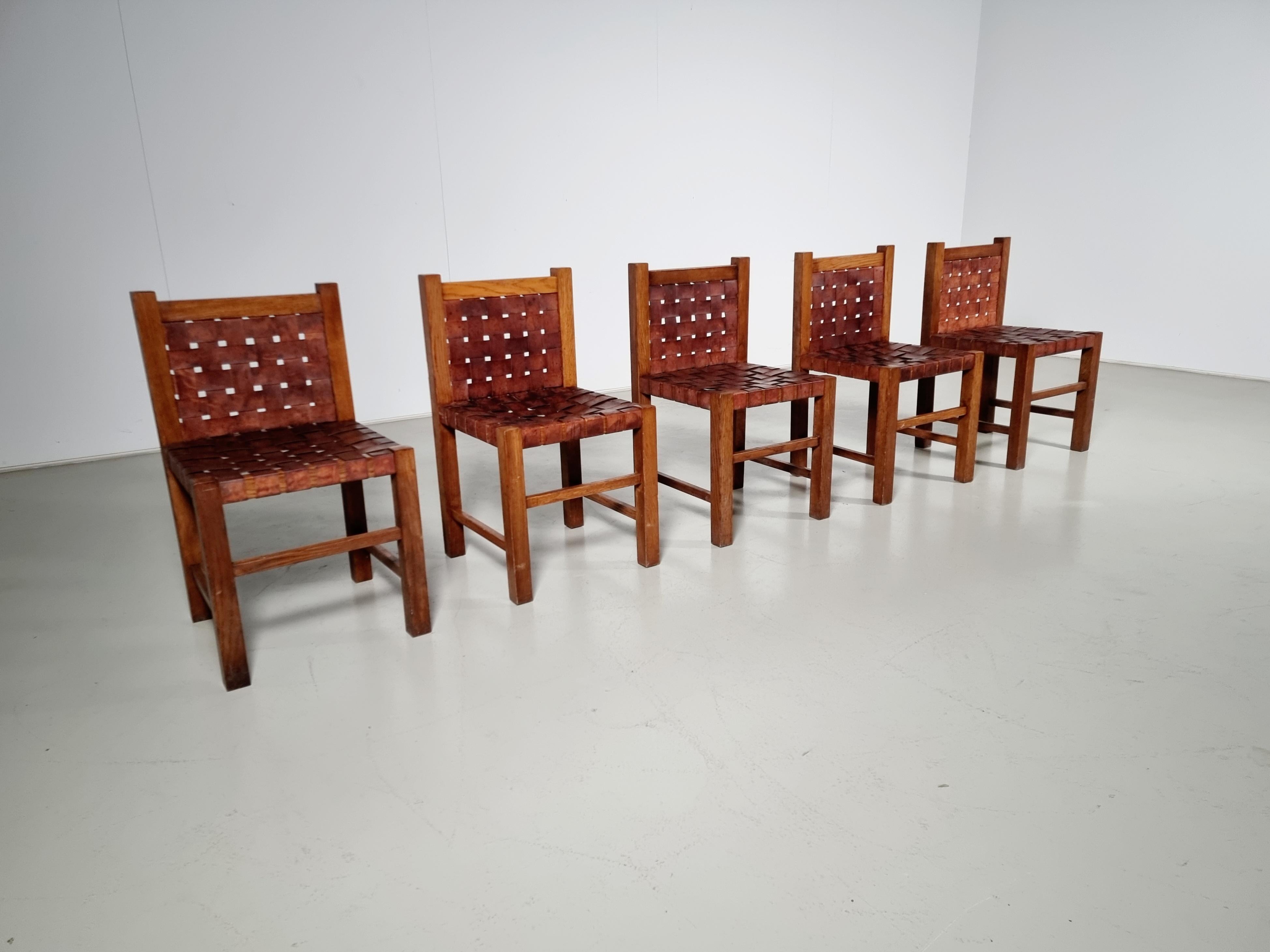Set of 5 brutalist solid oak dining chairs from the 1970s. Bulky chairs with amazing seating comfort because of the woven leather seats and backs. 

Defined by clean, smooth lines, and excellent joinery, each of these dining chairs was created by