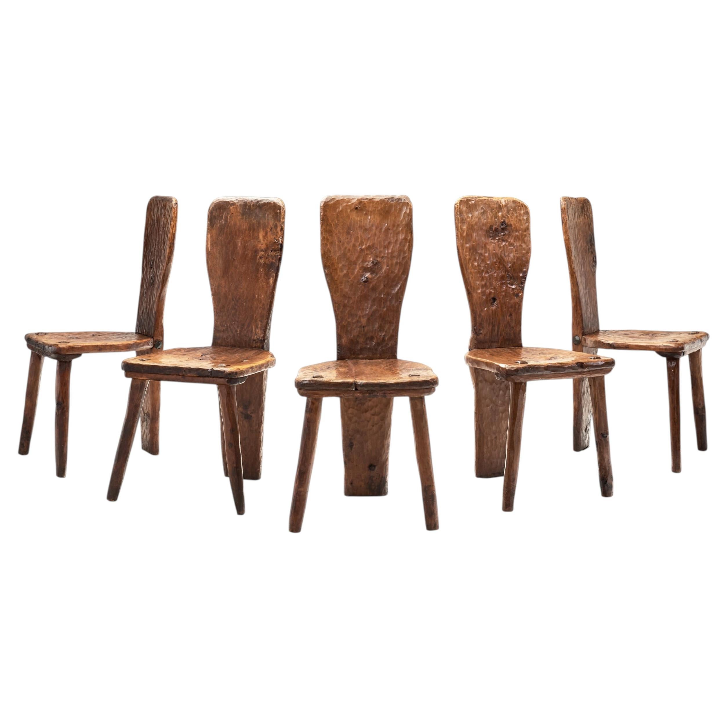 Lot de 5 chaises de salle à manger à dossier droit en planches massives, avec motif sculpté, Europe, milieu du XXe siècle. en vente