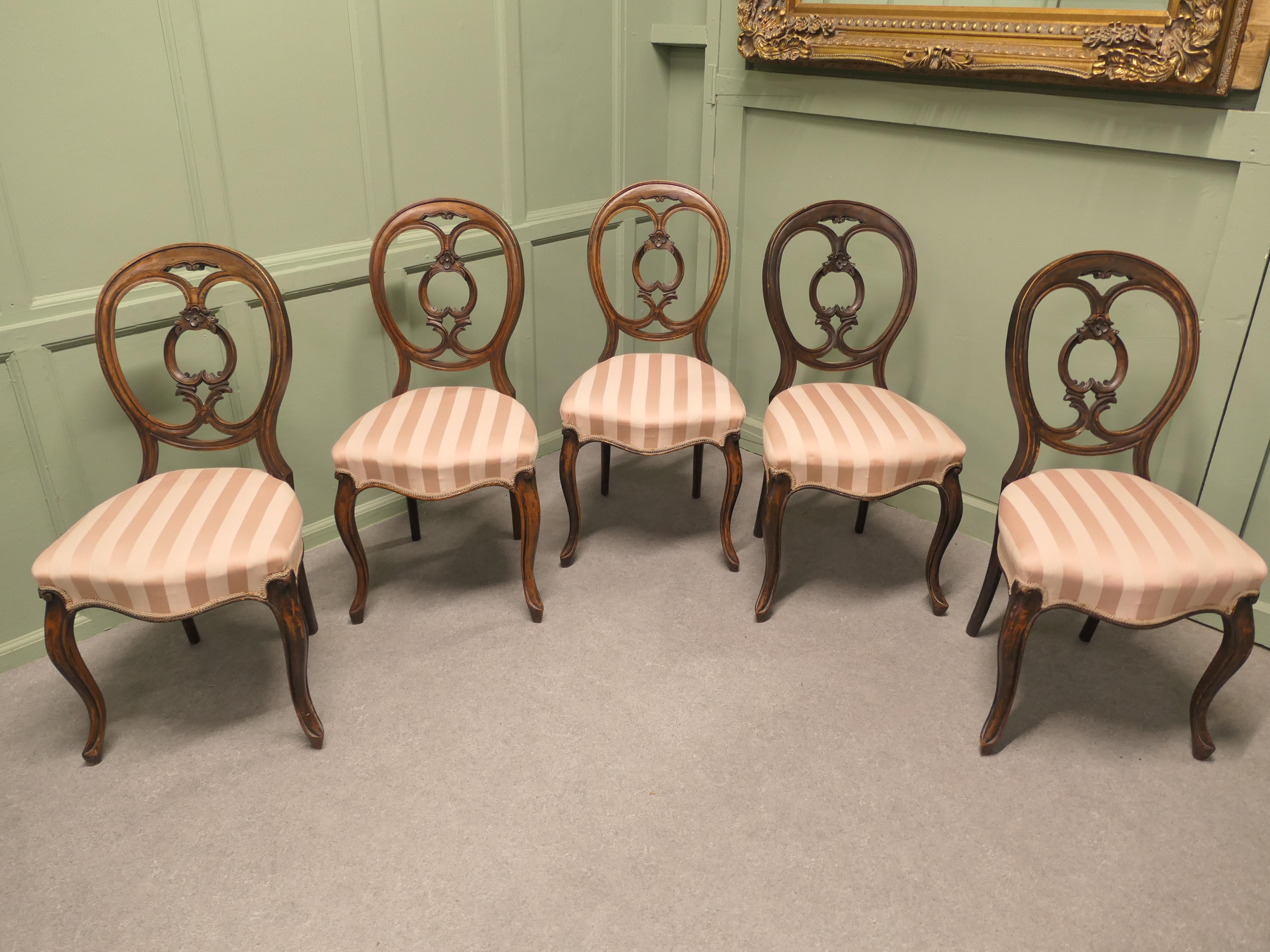 Set of 5 Victorian Balloon Back Dining Chairs 

The Chairs have a decorative carved Balloon Style Backs with old regency stripe upholstered seats.  The set is sound with no loose joints or wobbles, a very attractive set

The chairs are 35” high at