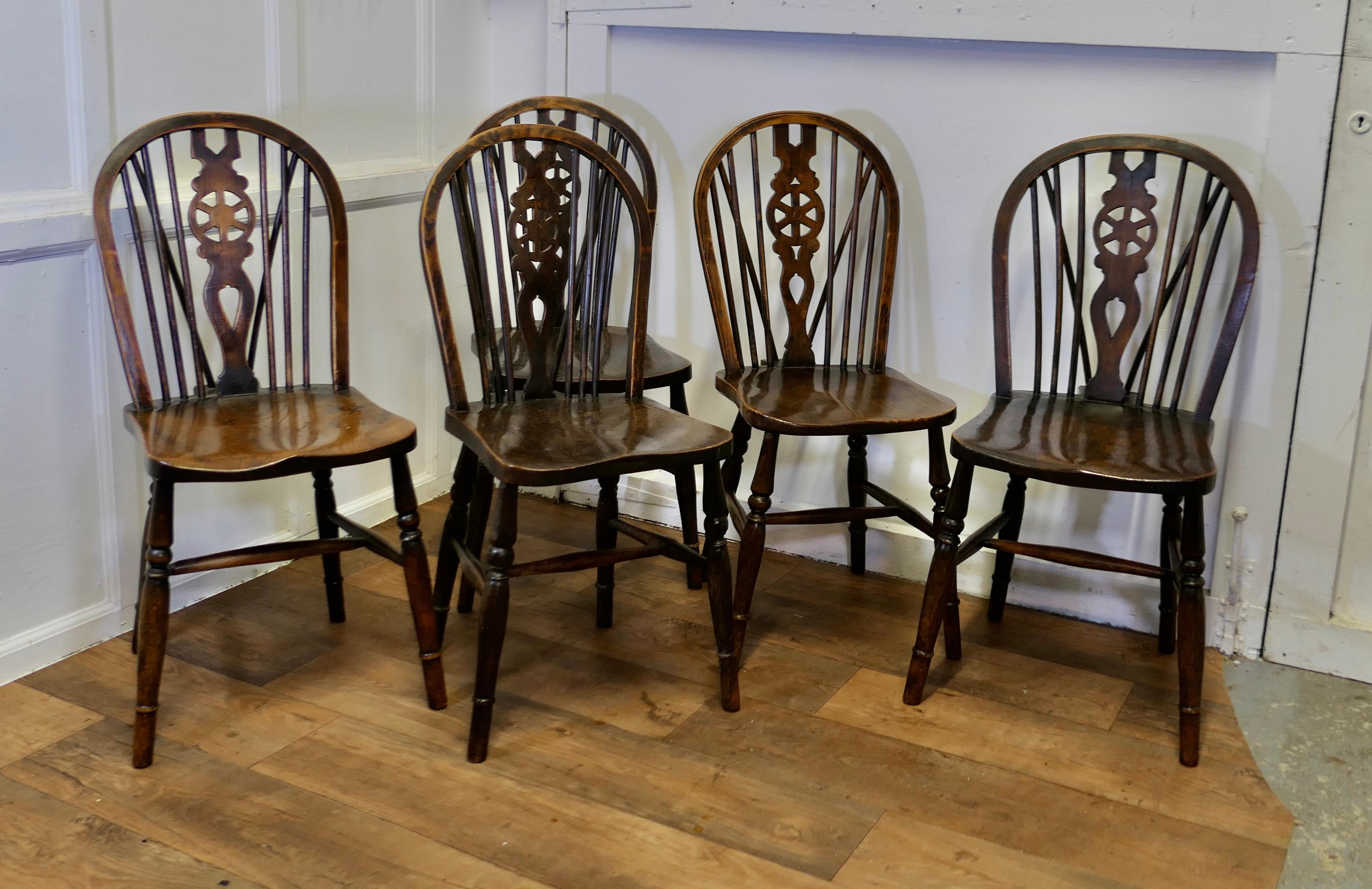 Set of 5 Victorian Beech & Elm Wheel Back Windsor Kitchen Dining Chairs

The chairs are a classic design and traditionally made from solid wood they have hooped backs with a wedge in the traditional Windsor style, the back centre splat in the shape