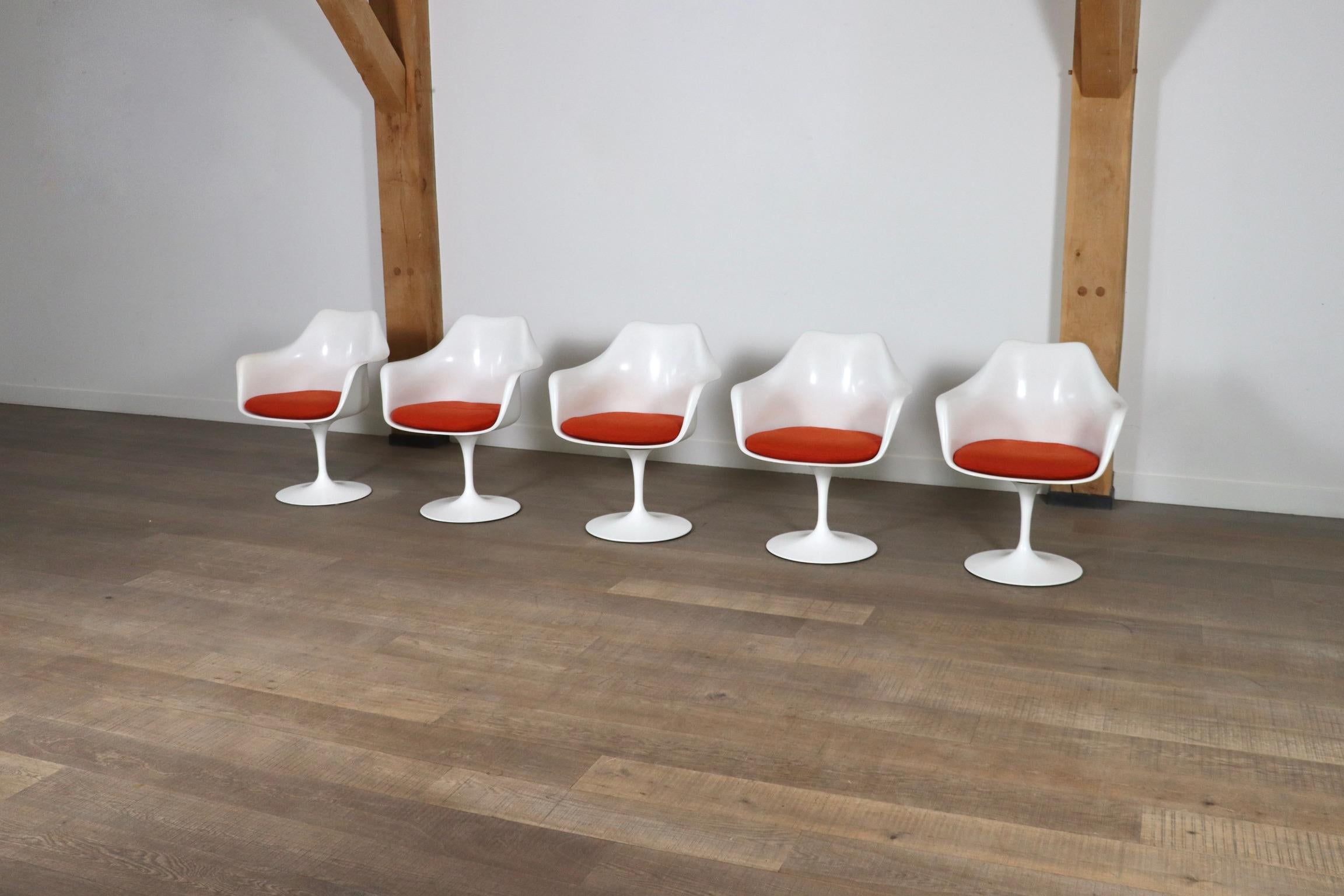 Amazing set of 5 Tulip chairs in original burnt orange upholstery by great designer Eero Saarinen, 1970s. This particular set has three fixes chairs and two chairs with a swivel base. The chairs are marked with the Knoll sticker. This timeless