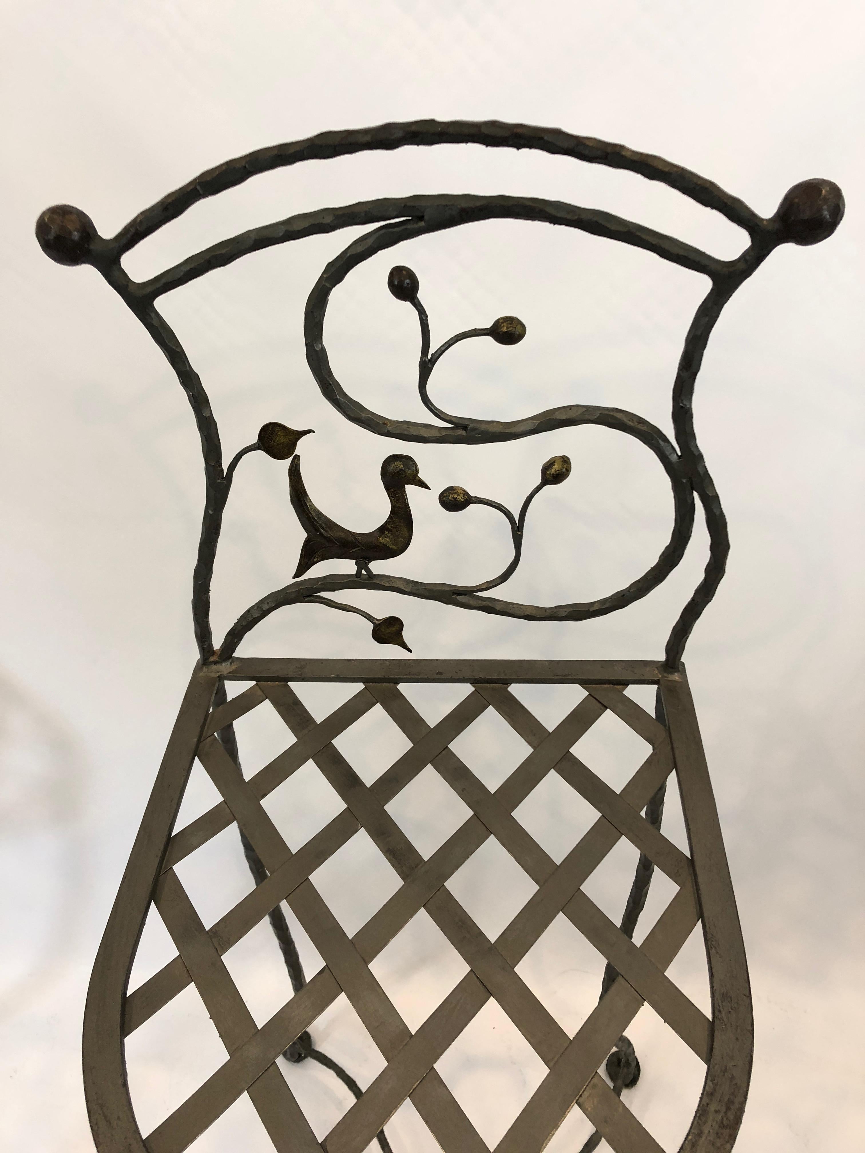 Wonderfully original set of counter stools made of hand forged iron, having a whimsical bird and branch design on the backs and asymmetrical cross bars at the feet. 
Measures: Seat 13.75 W x 26 h x 16 D.