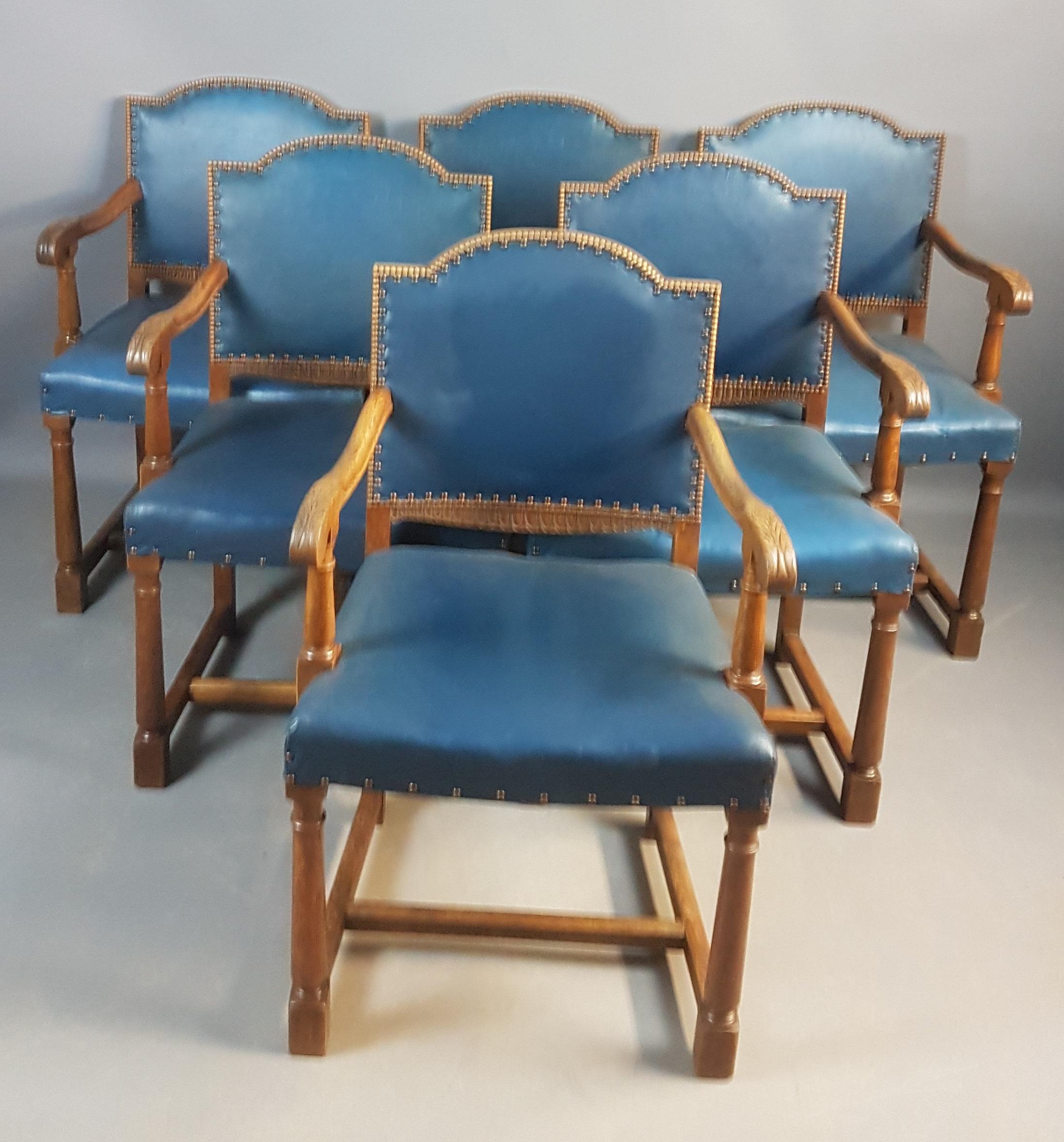 A very nice set of 6 oak armchairs of generous proportions, carved back sections and carved leafs on the arms. The arms and legs have reverse taper gun barrel turnings. The chairs are covered in regal blue leatherette that does have a few marks but