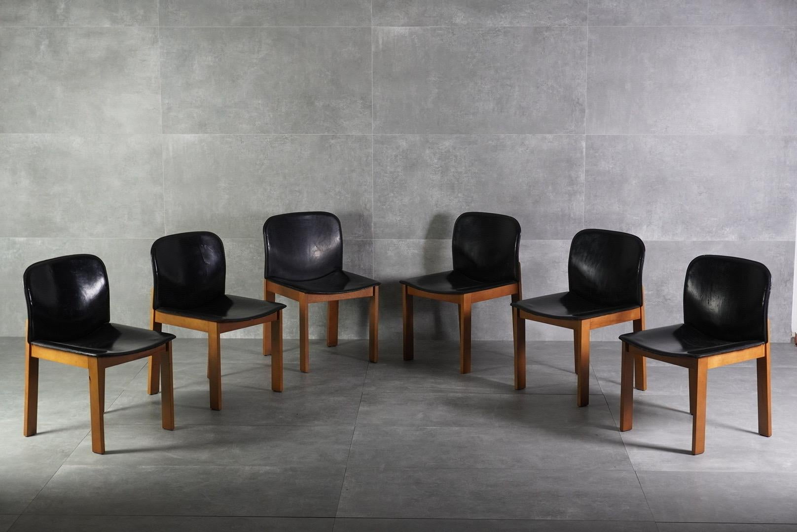 Elegant set of six italian dining chairs from the 1970s. Featuring solid wood frames and original leather seats and backrests, these chairs embody timeless modern design with warm materials.