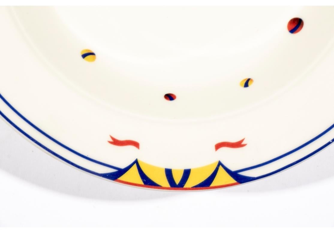 Set of six oval porcelain soup bowls designed by Adam D. Tihany for Le Cirque and made by Villeroy & Boch. The bowls are decorated with yellow circus big tops flying red flags and scattered colorful balls with double blue trims. Marked on verso