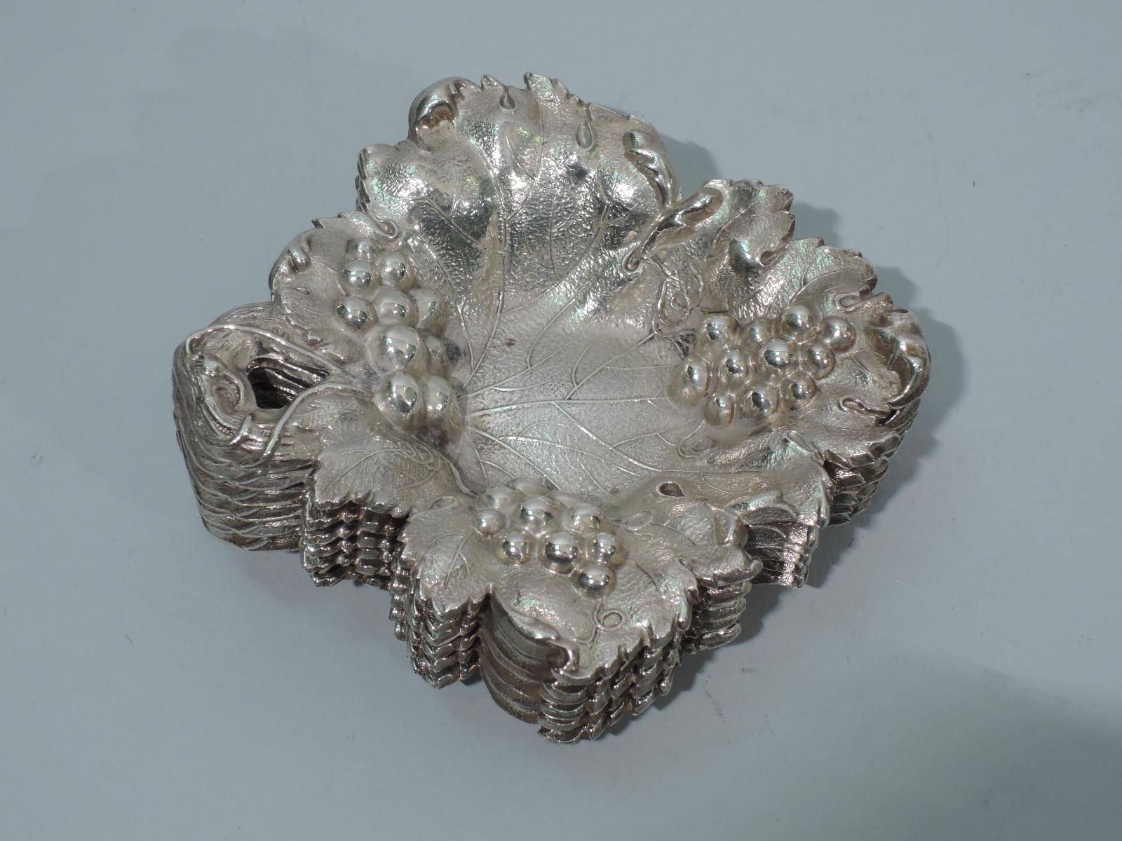 Ensemble de 6 plats à noix figuratifs en argent sterling américain du début du siècle. Chacune : Feuille en forme de losange irrégulier avec des nervures gravées et des grappes de raisin en relief. Poignée de vigne ouverte. Finition Butler.