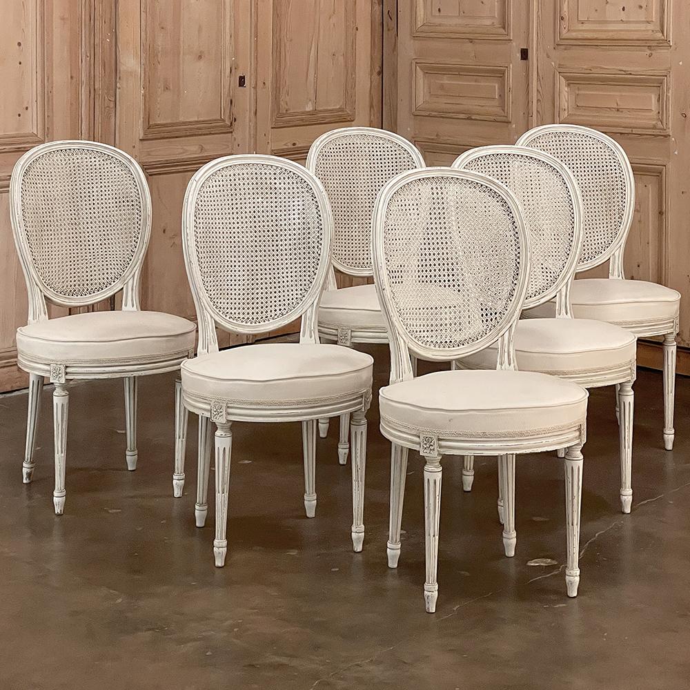 Set of 6 Antique French Louis XVI Painted Dining Chairs with Cane Backs are the perfect choice to provide timeless neoclassical styling with fine dining comfort! The oval, contoured seatbacks are caned for light weight, ideal for southern climates,
