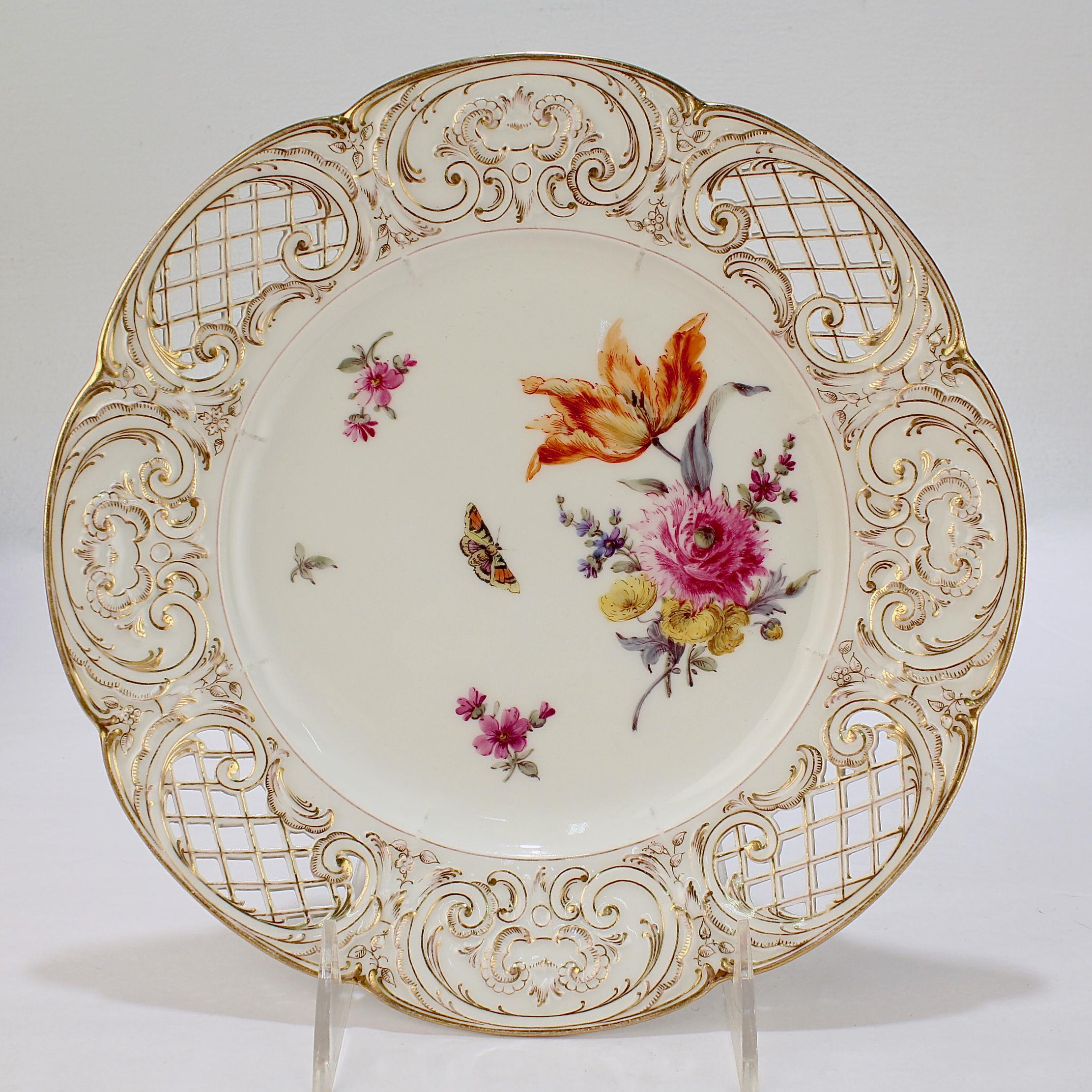 Fino juego de platos de gabinete de porcelana reticulada.

Por KPM (Königliche Porzellan-Manufaktur).

Cada una con ramilletes de Deutsche Blumen pintados a mano, ramitas florales, insectos y mariposas. 

El borde festoneado, reticulado y en relieve