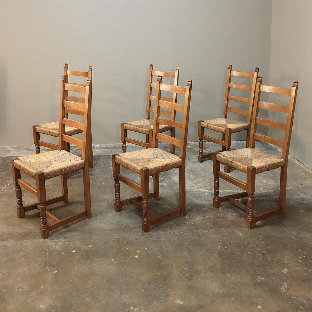 Set of 6 antique rustic country French dining chairs feature ladder backs, turned legs and rush seats for a Classic casual look! Each was handcrafted from solid oak using time-honored techniques that interconnect the framework to the structure for a