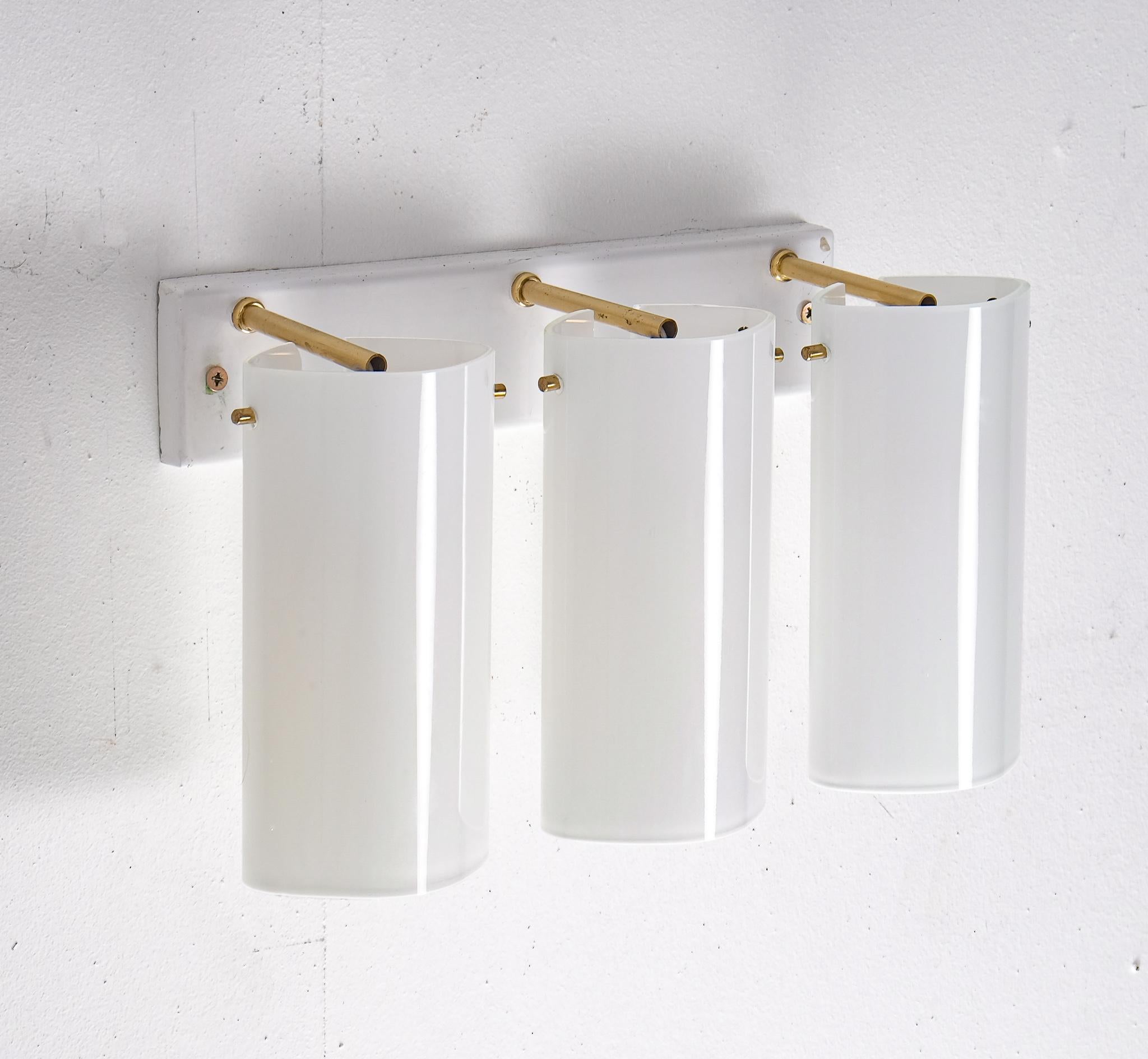 Rare model. Set of 6 available. 3-armed, opaline glass and brass. Produced by Fagerhults, late 1960s.
Please note: Listed price is for one (1) wall lamp.
