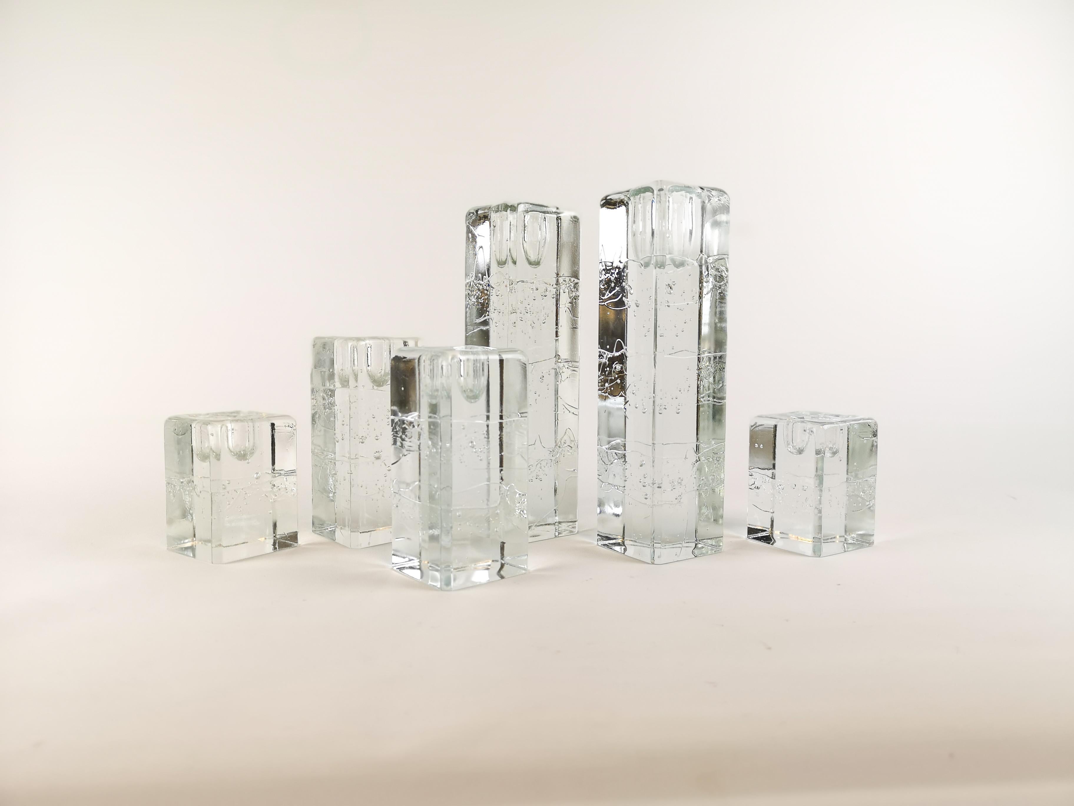 Group of 6 Iittala Arkipelago candlesticks in square high forms.
Architectural cast clear glass blocks.
With bubbles. They are created to appear as if they were is blocks. They are designed by Timo Sarpaneva in the 1970s for Iittala