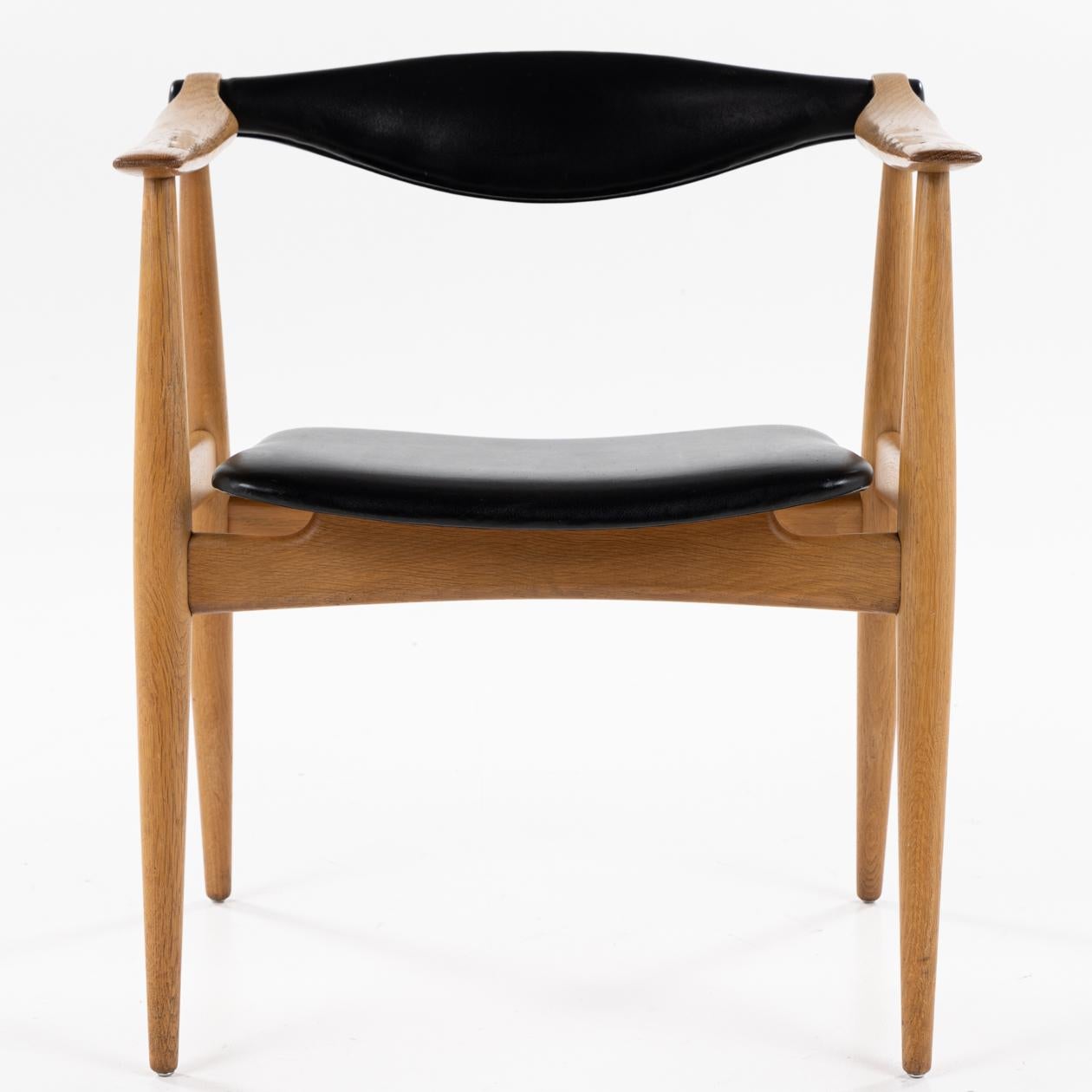 CH 34 - ‘Yoke' armchairs in lacquered oak and black leather. Backrest with tilt. Hans J. Wegner / Carl Hansen