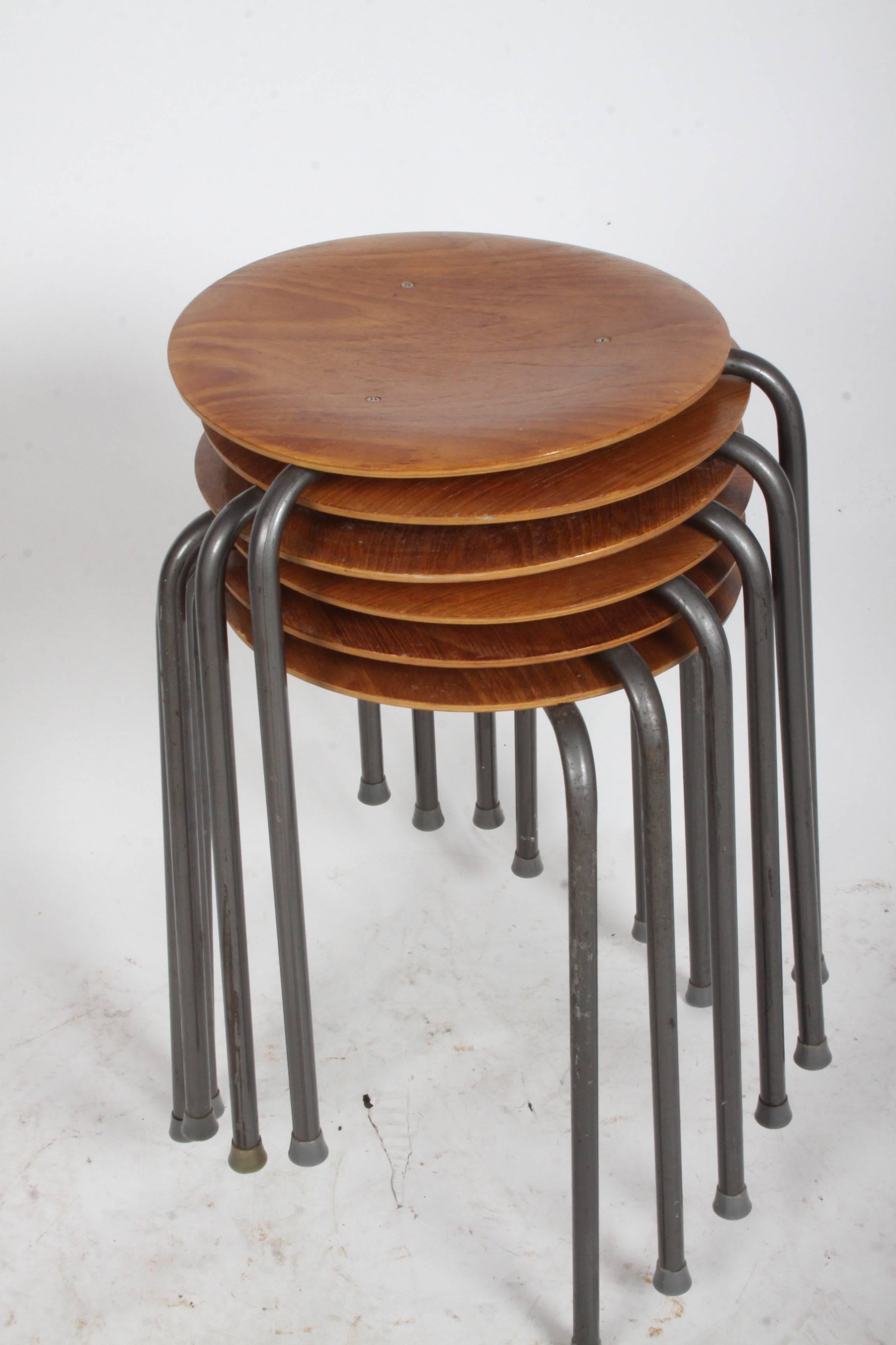 In the style of Arne Jacobsen for Fritz Hansen dot stacking stools or tables, stamped made in Denmark. Original finish to teak and metal. Danish modern. In the style of Tony Paul's stacking tables.