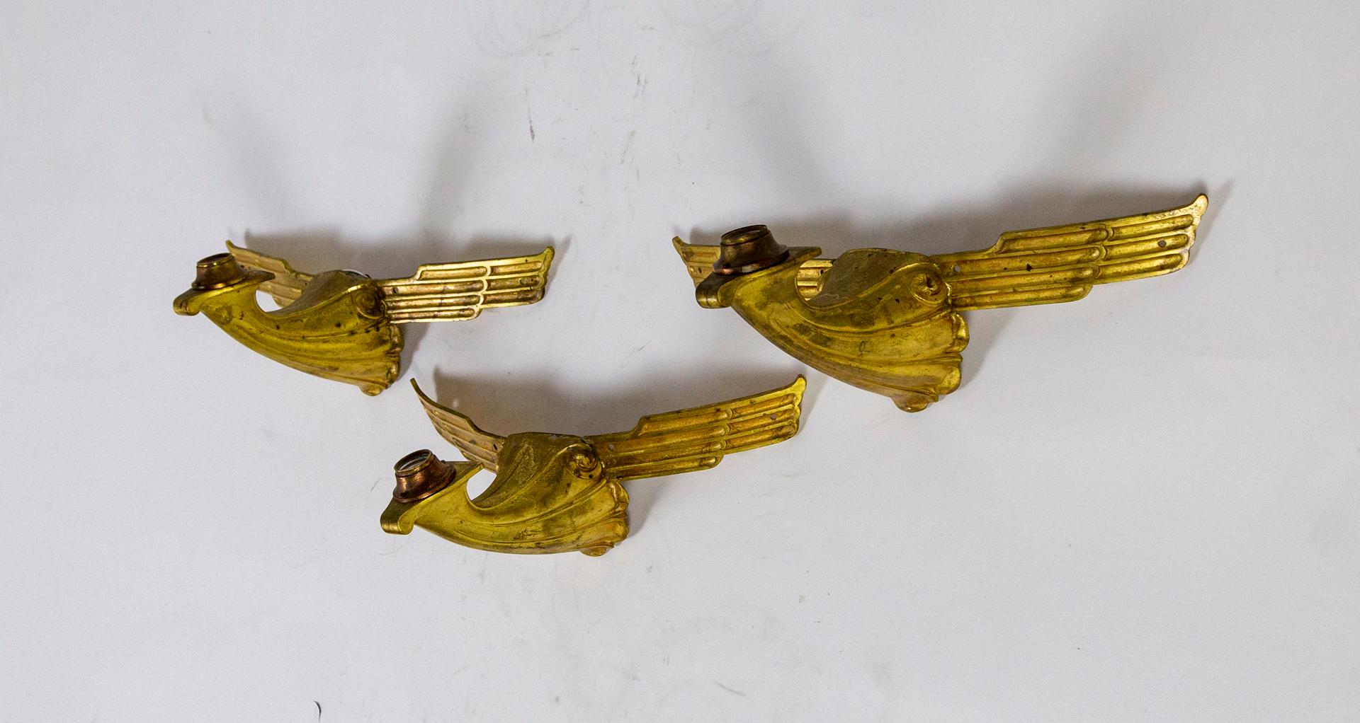 A set of 6 sconces originally installed on columns of the historic, temple-like Fox Theater which opened in Oakland, California in 1928. The Art Deco design, cast in solid bronze and gilded, conveys the front of an abstracted bird with outstretched