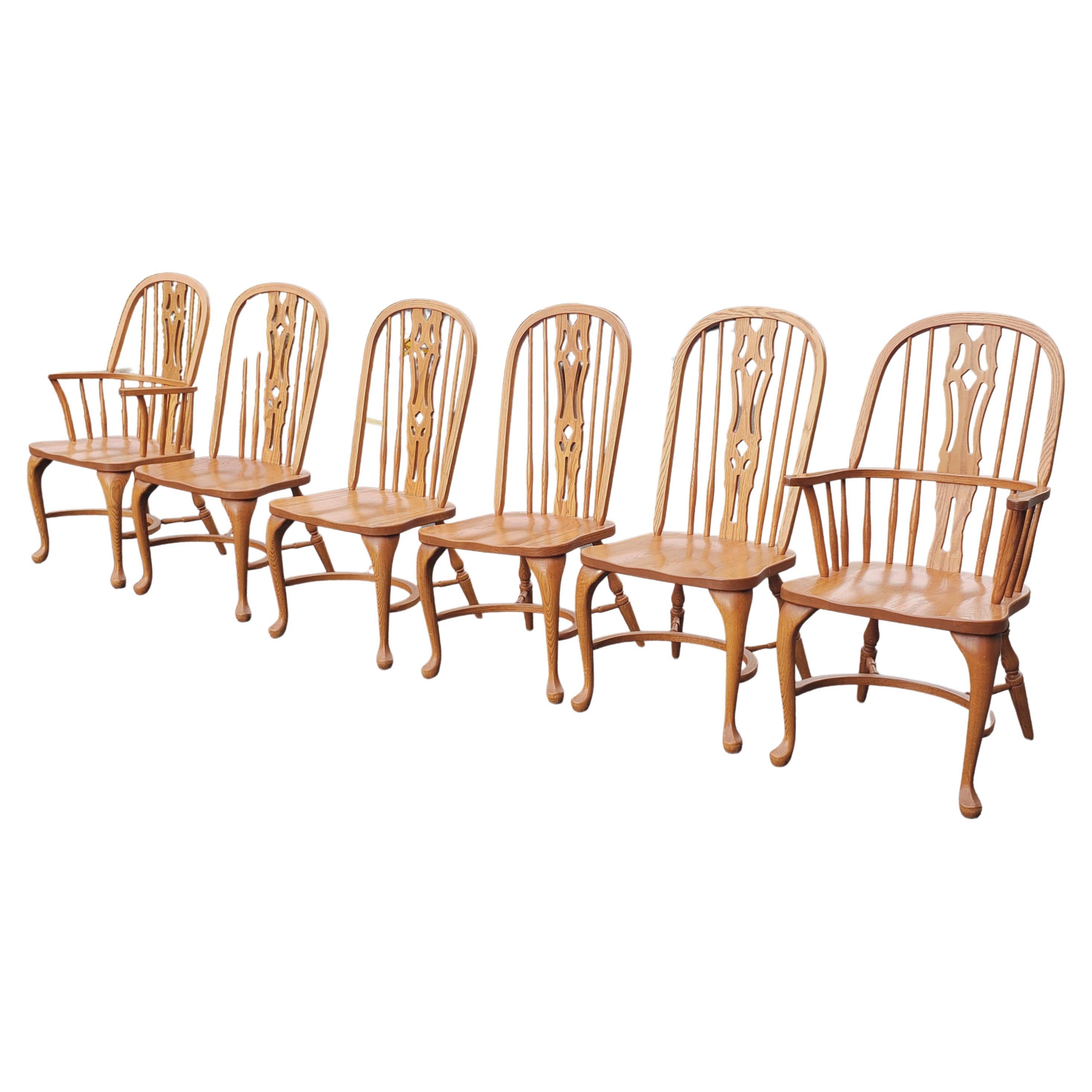 A great Set of 6 Arts and Crafts Americana Solid Oak Windsor chairs crafted in Lancaster Pennsylvania by fine Amish artisans. Chairs feature saddleback seats and carved through fretwork backs. Set comes with 4 side chairs and 2 captain armchairs