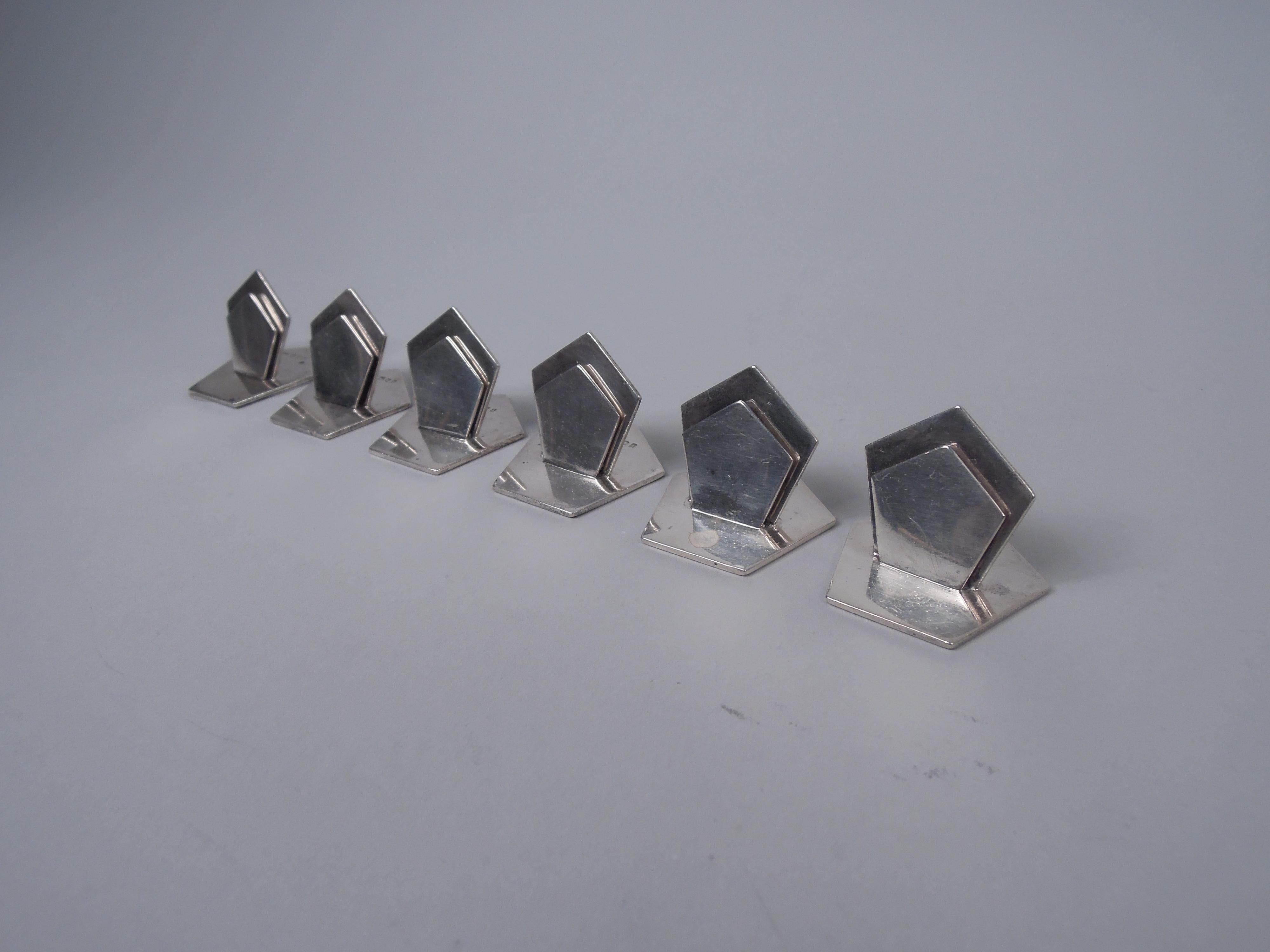 Set of 6 Art Deco sterling silver place card holders. Made by Asprey 
Co. in London in 1926. Two graduated vertical pentagons forming clip mounted to horizontal same. Fully marked. Total weight: 4.7 troy ounces. 