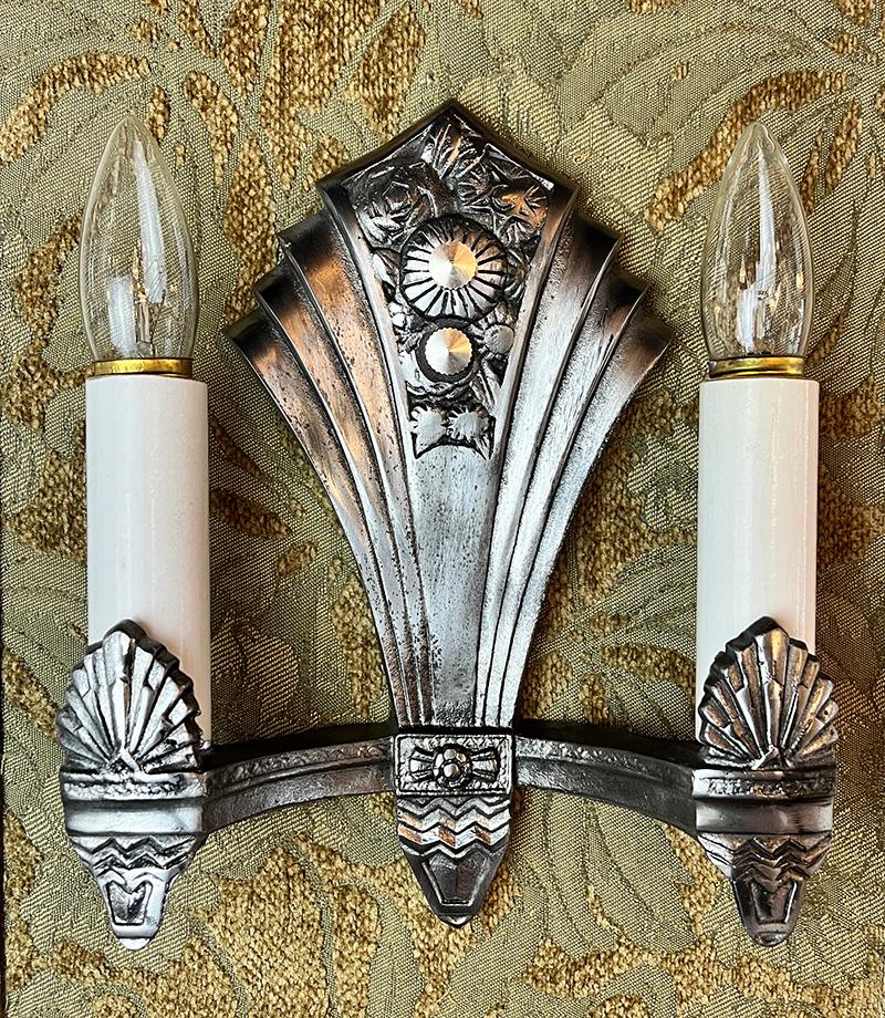 Beautiful set of 6 of original 1930s Art Deco sconces double light sconces. Restored original finish featuring a floral motif in the center and a chevron and fan pattern on the arms and back plate. Sold as pairs or as a set of 4 or 6.  With a 2 3/4