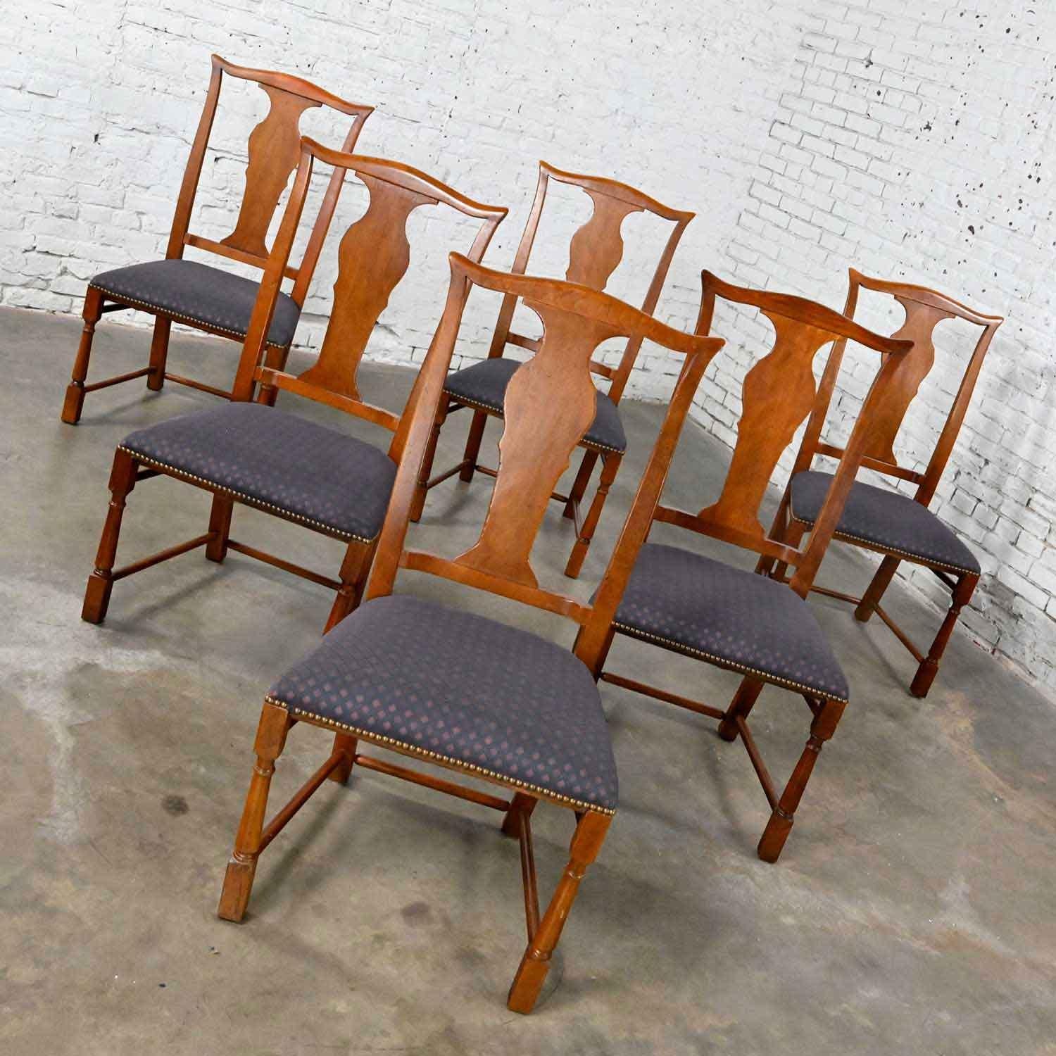 Handsome set of six Baker dining chairs in a Chippendale style with a solid back splat and turned front legs with stretchers, original finish, and upholstery with antiqued brass nail head trim. Beautiful condition, keeping in mind that these are