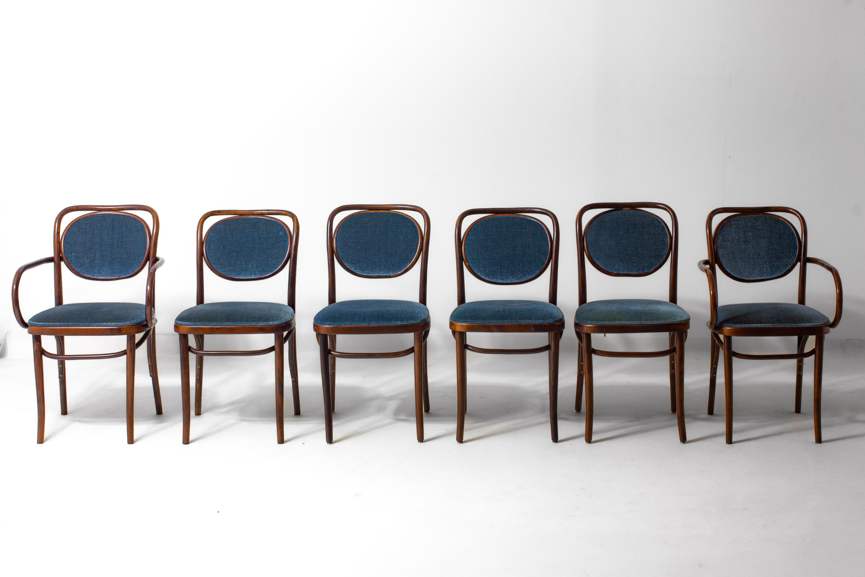 Set di sei sedie da pranzo in legno curvato disegnate da Josef Hoffmann e prodotte da Thonet negli anni Sessanta. Il set comprende quattro sedie laterali e due poltrone. Le strutture sono realizzate in faggio tinto scuro con le tipiche linee curve,