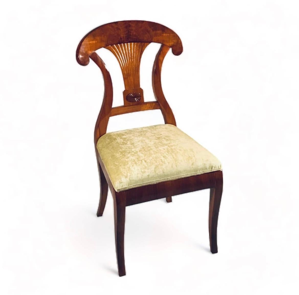 This elegant set of six Biedermeier chairs comes from Southern Germany and dates back to around 1820. The walnut chairs stand out for their exquisite back design, a combination of a shovel back design with a beautifully shaped fan decor in the