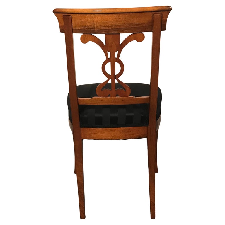 This set of 6 Biedermeier dining chairs has a pretty walnut veneer. The chairs stand pout for their gorgeous backrest decor. They come fully refinished with a shellac finish, new upholstery, and an elegant black JAB Anstoetz fabric. 

