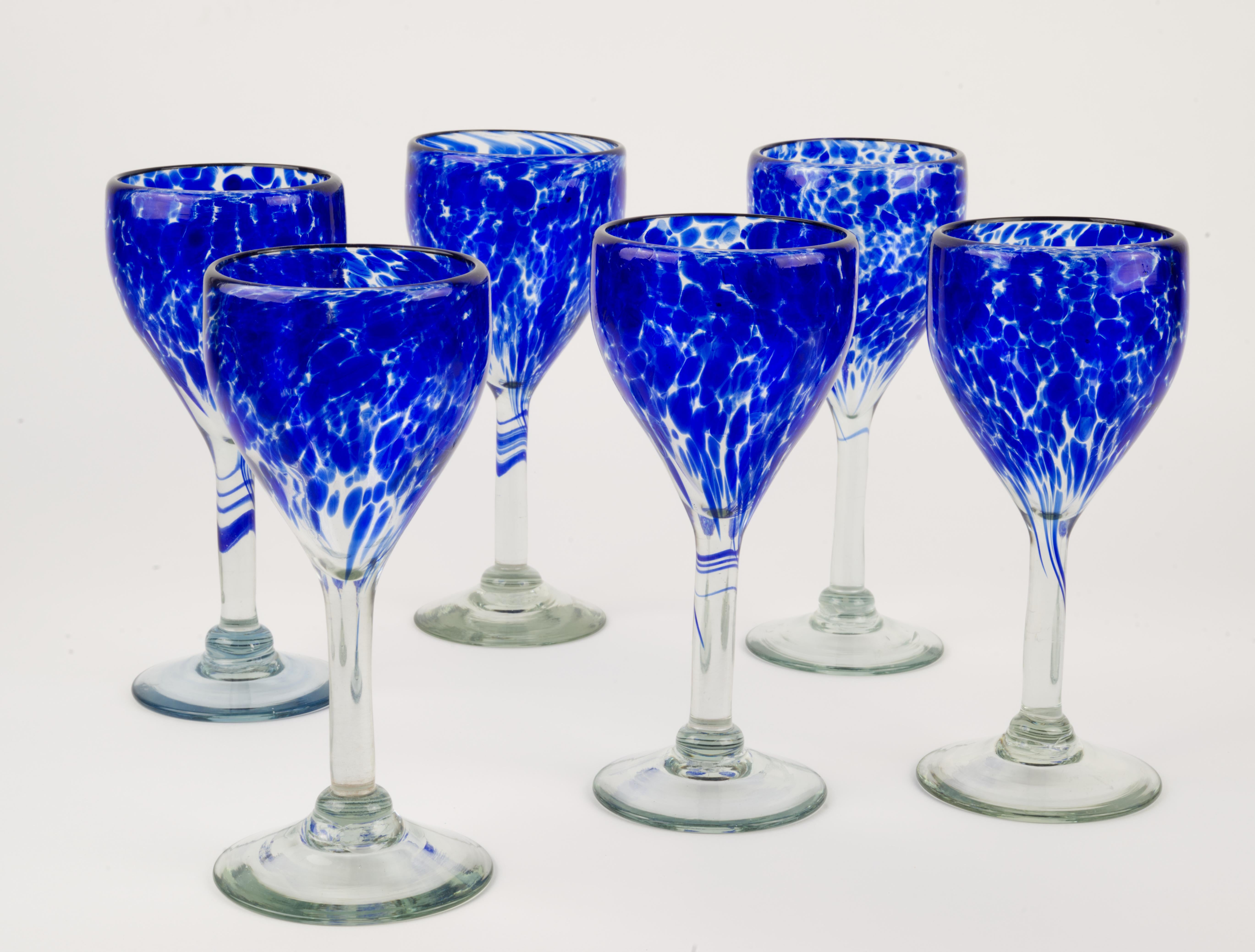  Il set di 6 bicchieri da acqua o da vino blu cobalto e trasparenti è stato soffiato a mano da artisti messicani in stile organico e moderno. Le forme astratte in vetro cobalto si muovono verso l'alto e intorno al corpo del calice, realizzato in