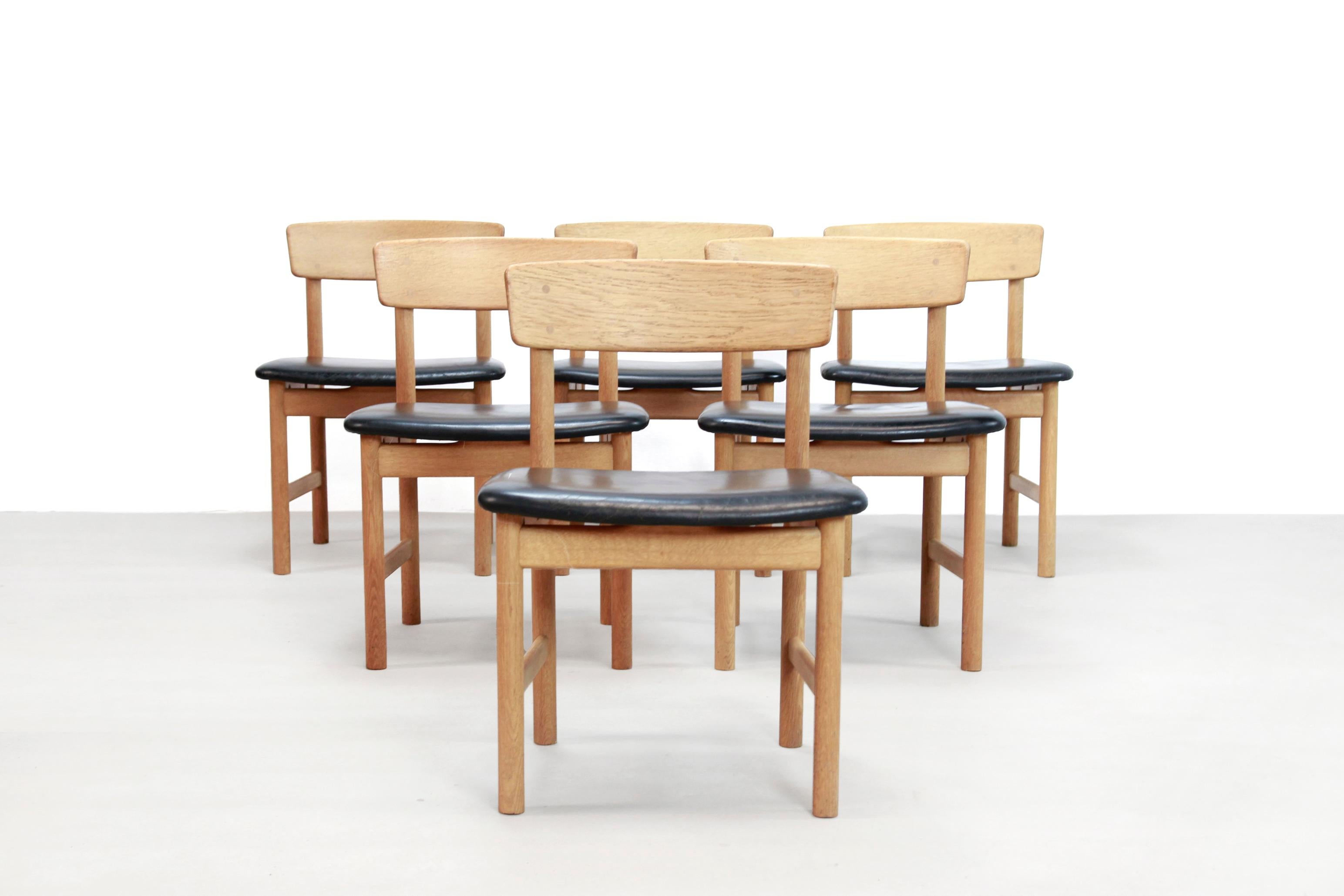 Beautiful oak Danish design dining room chairs upholstered with black leather, which is designed by Borge Mogensen and produced by Fredericia. These chairs have the beautiful natural and Minimalist Shaker design what we are used to from Mogensen.