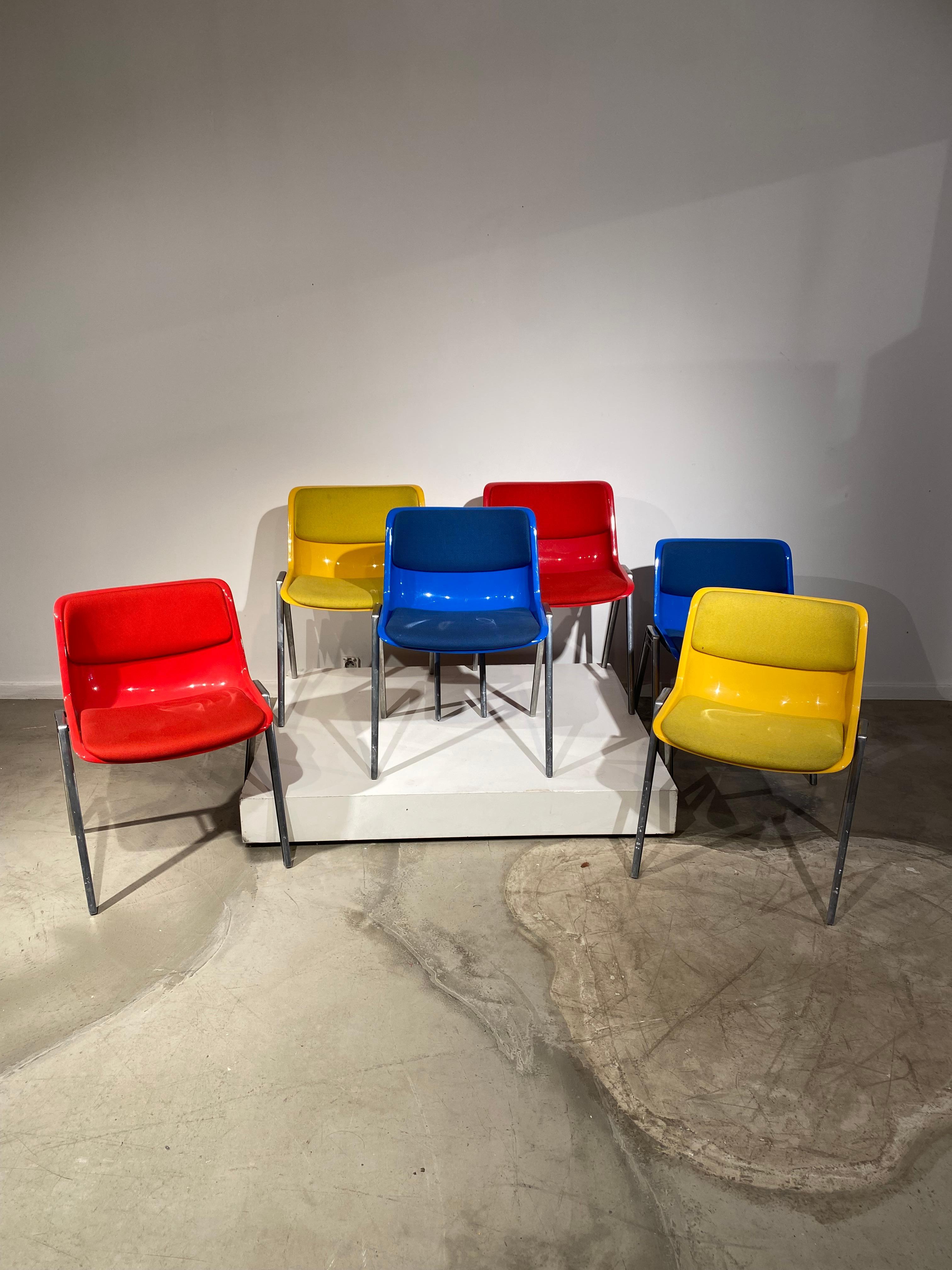 Set of really nice set of 6 chairs by Orsvaldo Borsani and edited by Tecno during 70s in Italy. We have 2 yellow chairs, 2 blue and 2 red.
The colored fabric contrast with the metallic legs finished by a black detail. 
Great pieces to add a touch