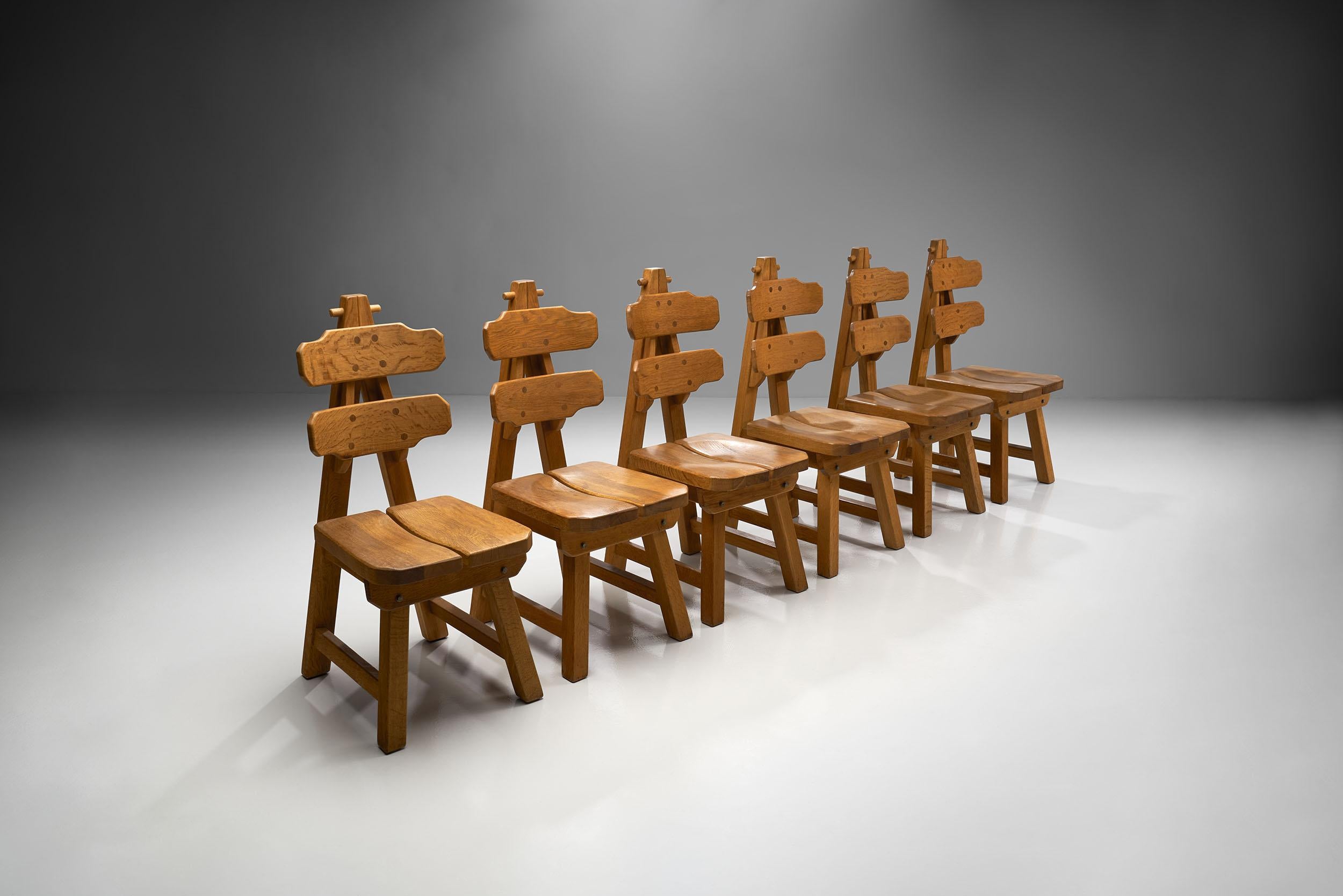 Impressive set of six oak brutalist chairs, Spain, circa 1970. This set features six exquisitely sculptural and geometrical brutalist chairs. The marks of Brutalism can be observed in the unornamented, solid wood, exposed joints, and raw oaken