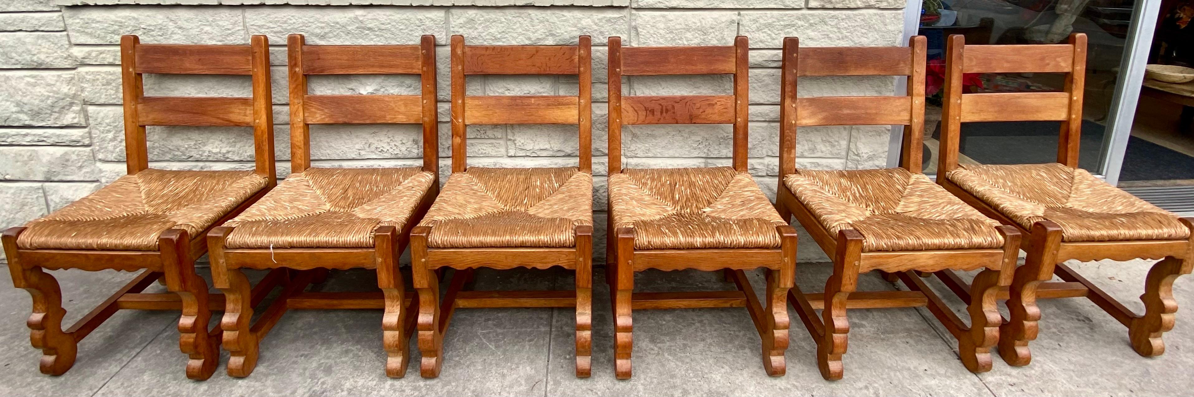 Set of 6 solid oak brutalist dining chairs with rush seats, France, circa 1960s. 
Dimensions: 19