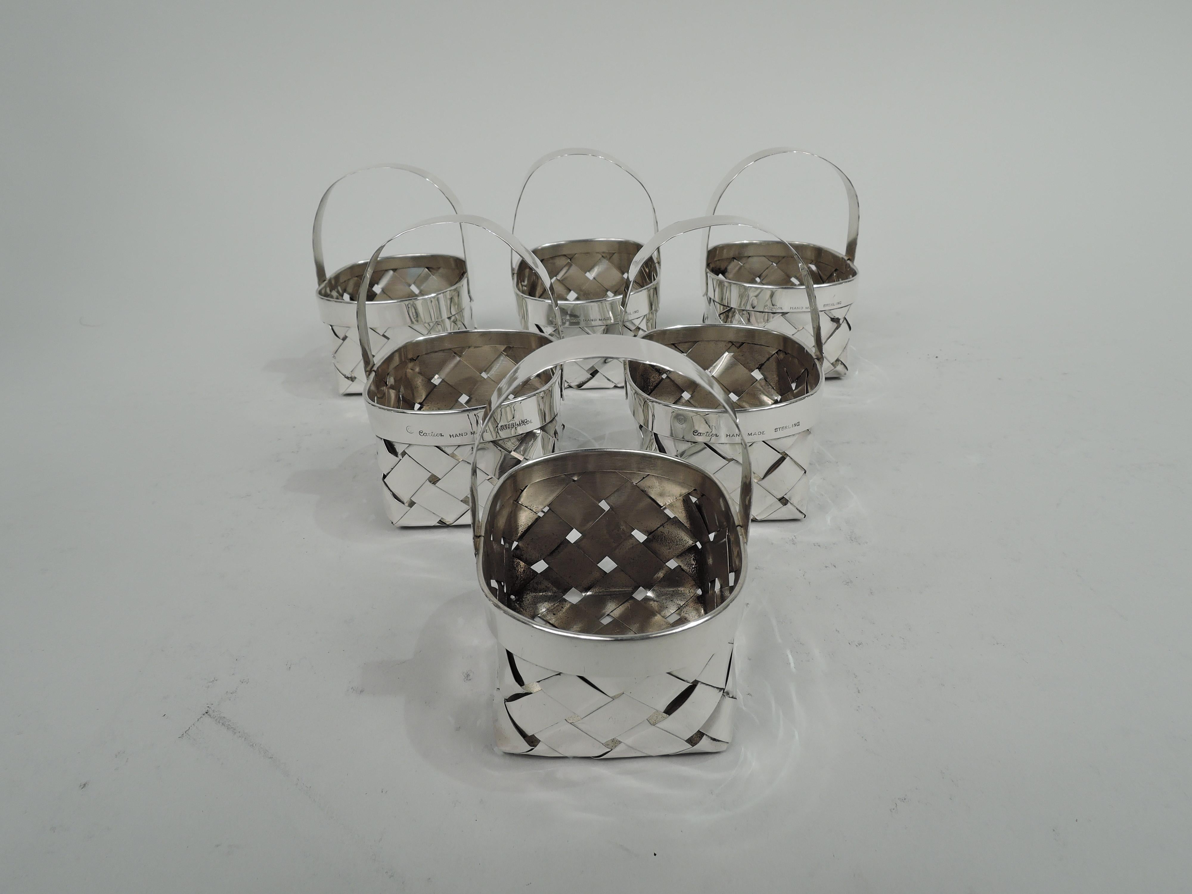 Set of 6 Mid-Century Modern sterling silver baskets. Retailed by Cartier in New York. Each: Rectangular with woven sides and bottom. Plain and solid rim forming oval mouth and fixed c-scroll handle with “stitched” rims. The small splurge-Size