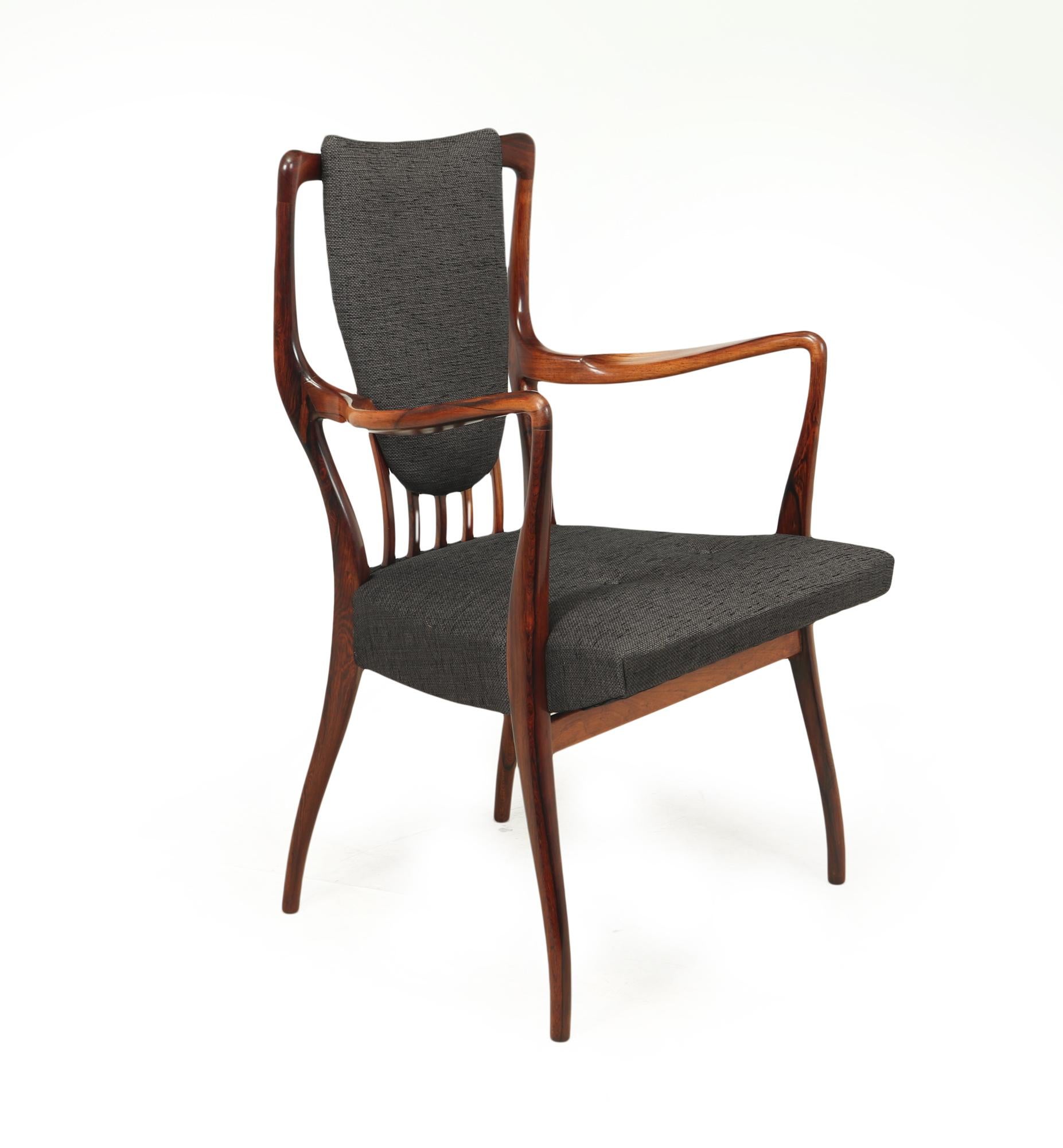 A set of six carver arm chairs designed in 1947 by Andrew J Milne and retailed by Heals through the middle of the 20th century, the chairs are solid rosewood sculpturally carved and shaped to make this super stylish and comfortable design, as you