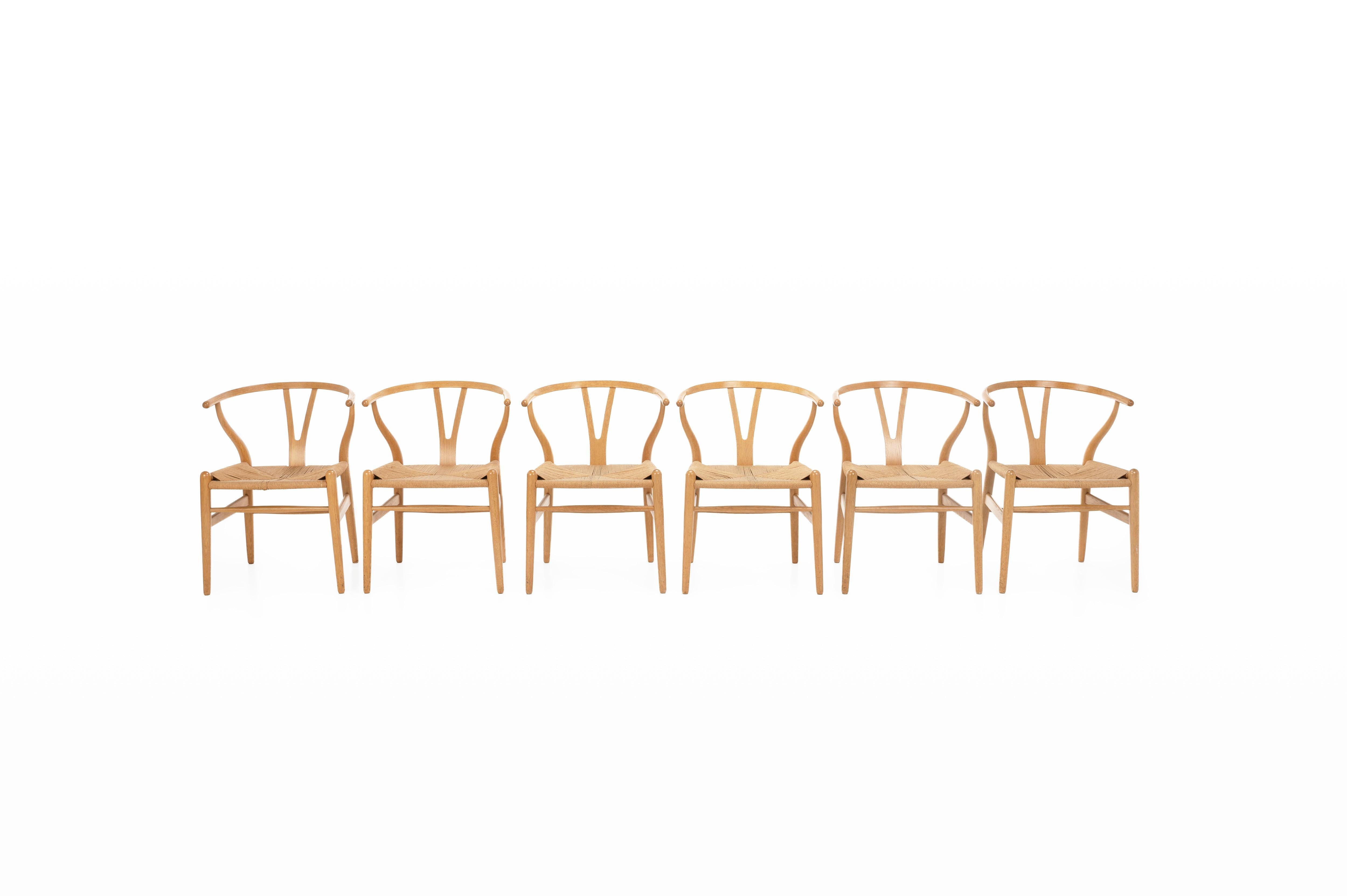 Ensemble de six chaises de salle à manger 'CH24' conçues par Hans J. Wegner pour Carl Hansen, Danemark. Les chaises ont un cadre en chêne avec un vernis naturel et une assise en corde de papier.

Dimensions :
L : 55 cm
D : 55 cm
H : 72 cm