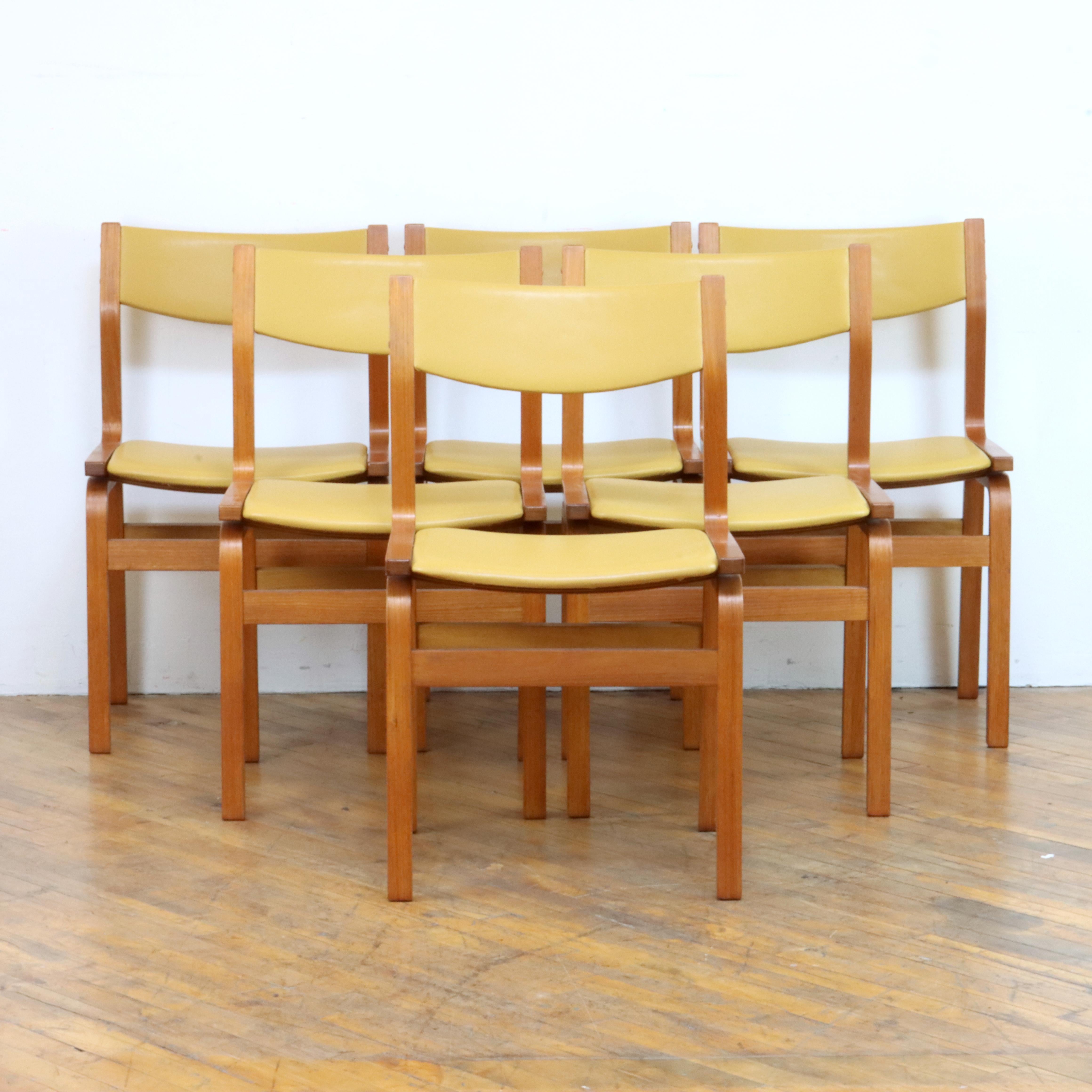 Lovely set of Danish dining chairs after Arne Jacobsen's St. Catherine's chair, designed for St. Catherine's College in Oxford, England. Simple and elegant, the chairs are constructed with teak veneered molded plywood and were just reupholstered in